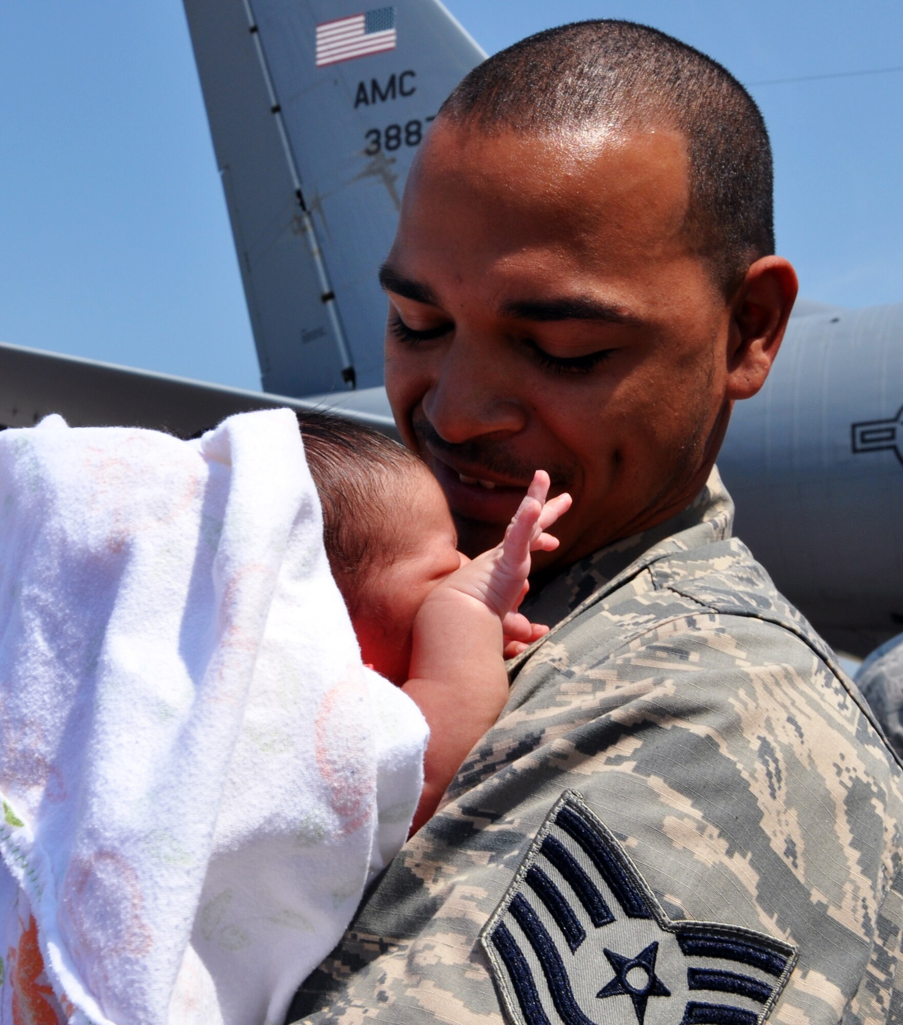 Tech. Sgt. Saxton Calton, an Air Force Reservist assigned to the 931st Air Refueling Group, holds his three-week old daughter for the very first time upon his return home to McConnell Air Force Base, Kan., July 21, 2014.  Calton's daughter was born while he was serving on a 60-day deployment to Al Udeid Air Base, Qatar, as part of the 379th Air Expeditionary Wing.  (U.S. Air Force photo by Capt. Zach Anderson)   