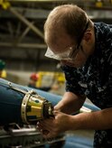 Petty Officer 3nd Class Brian Steelman, Navy Munitions Command mineman, routes an arming wire for a Mk 62 Quickstrike mine during an exercise July 16, 2014, at Joint Base Charleston, S.C. The Sailors in the mine shop routinely conduct drills and exercises to maintain their qualifications so they will be ready to deploy if necessary. (U.S. Air Force photo by Senior Airman Dennis Sloan)