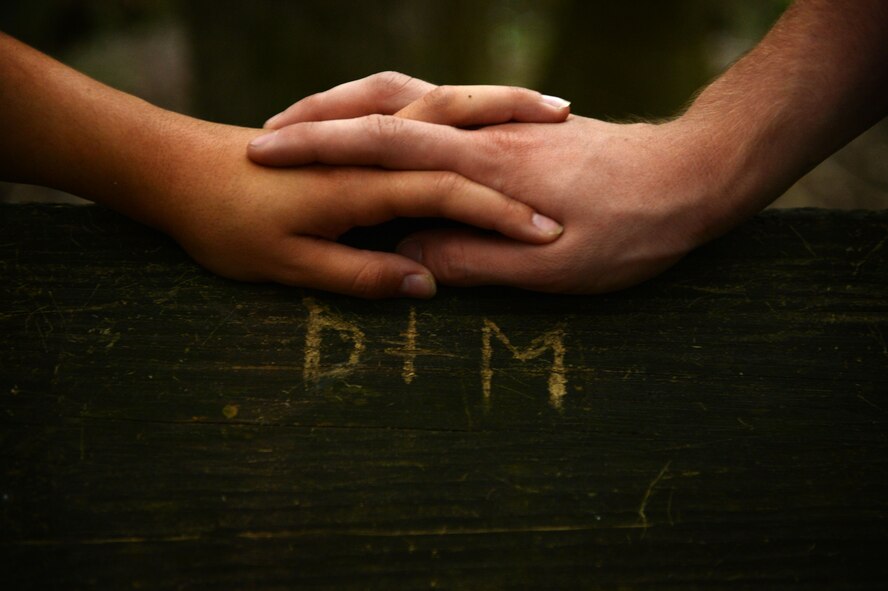 U.S. Air Force Airmen 1st Class, Michael and Diana Cossaboom, 20th Fighter Wing Public Affairs photojournalists, hold hands at Swan Lake and Iris Gardens near Shaw Air Force Base, S.C., July 19, 2014. The Cossabooms participated in a six week marriage mentorship program created by Chaplain (Maj.) Richard Holmes, 20th FW interim deputy wing chaplain, which helped the two learn communication methods along with answered their marriage questions. (U.S. Air Force photo by Airman 1st Class Jensen Stidham/Released)
