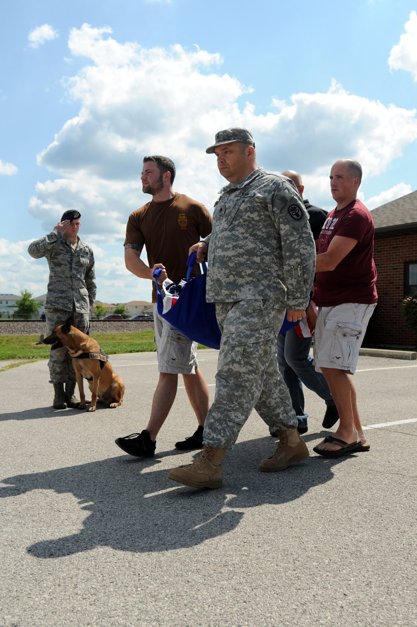 A 375th Security Forces member renders a final salute to Military Working dog Brix and his handler, Master at Arms Drew Risley, as they make their way out of the vets office to give him a military honors July 18, 2014 at Scott Air Force Base, Ill. Brix's health took a turn for the worse when he started having hip problems. Brix was awarded a Navy Marine Corp Achievement medal and an Army Commendation medal while being deployed in Iraq. He retired in 2011 upon returning from a deployment. (U.S Air Force photo/ Senior Airman Tristin English)