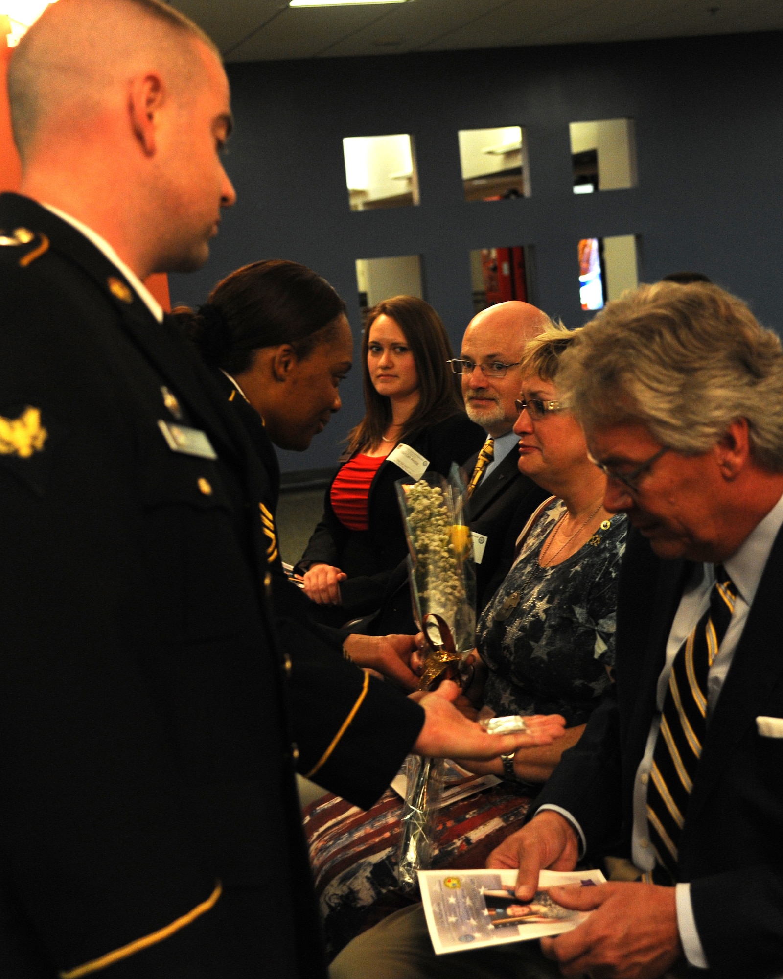 Sherry Wyatt receives a yellow rose while Randy Wyatt receives a coin during the dedication ceremony of U.S Army Specialist Sterling Wyatt at the St. Louis Military Entrance Processing Station in St. Louis, MO, July 17, 2014. Sterling Wyatt was killed in action when his vehicle was attacked with an enemy improvised explosive device. Wyatt received the Medal of Valor,Combat Infantry Badge and the Bronze Star. (U.S. Air Force photo/Senior Airman Tristin English)