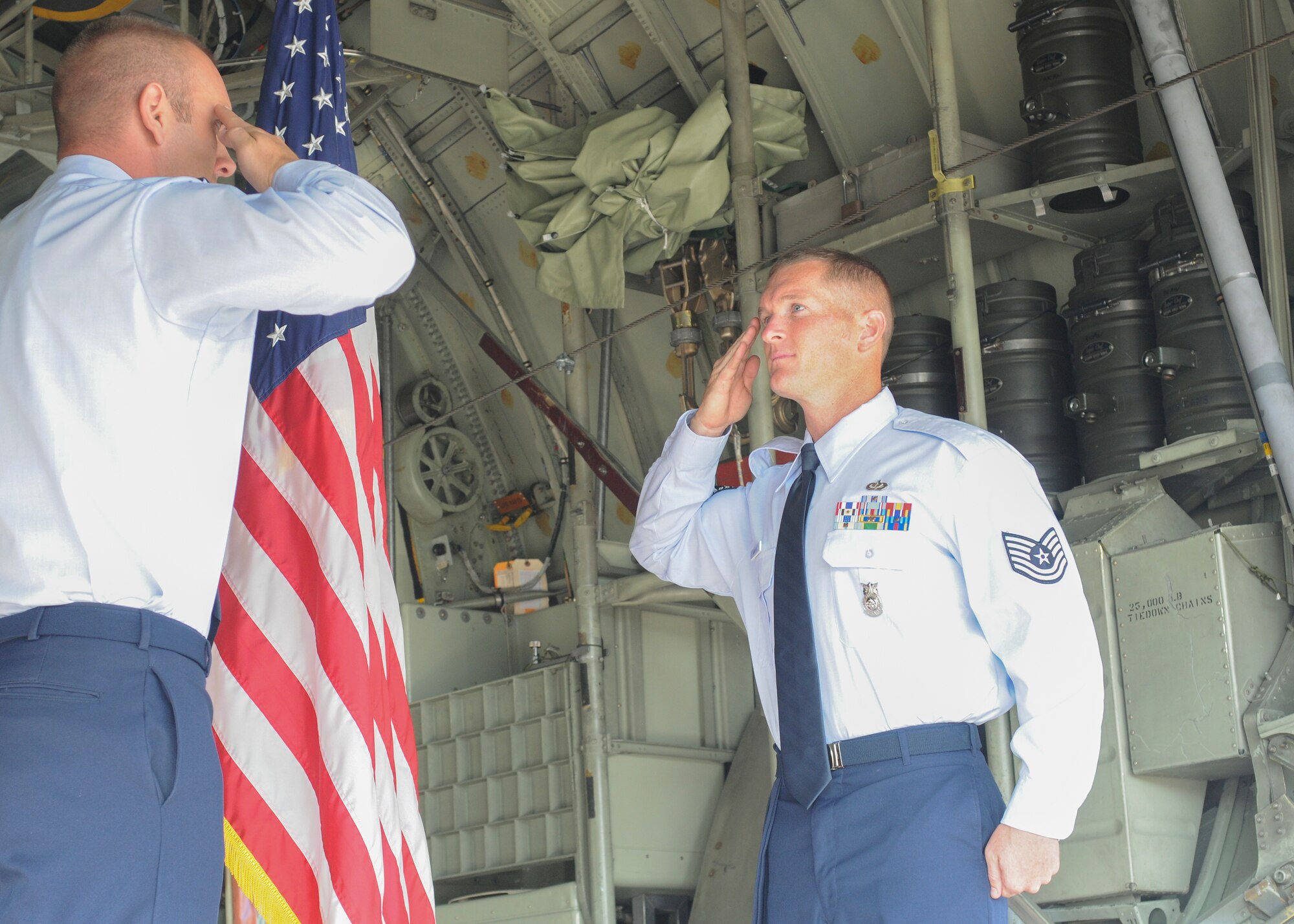 Tech. Sgt. Travis Newhart (right), a Fire Department training chief at the 910th Airlift Wing, salutes Capt. Nick Megyesi, an operations officer with the 911th Security Forces Squadron at Pittsburgh Air Reserve Station, after taking the oath of enlistment on the cargo ramp of a C-130H Hercules aircraft here, July 21, 2014. Longtime friends Newhart and Megyesi graduated from Jefferson High School and enlisted in the Air Force together approximately 14 years ago. Megyesi  travelled from Pittsburgh for the honor of reenlisting Newhart. U.S. Air Force photo/ Eric M. White.