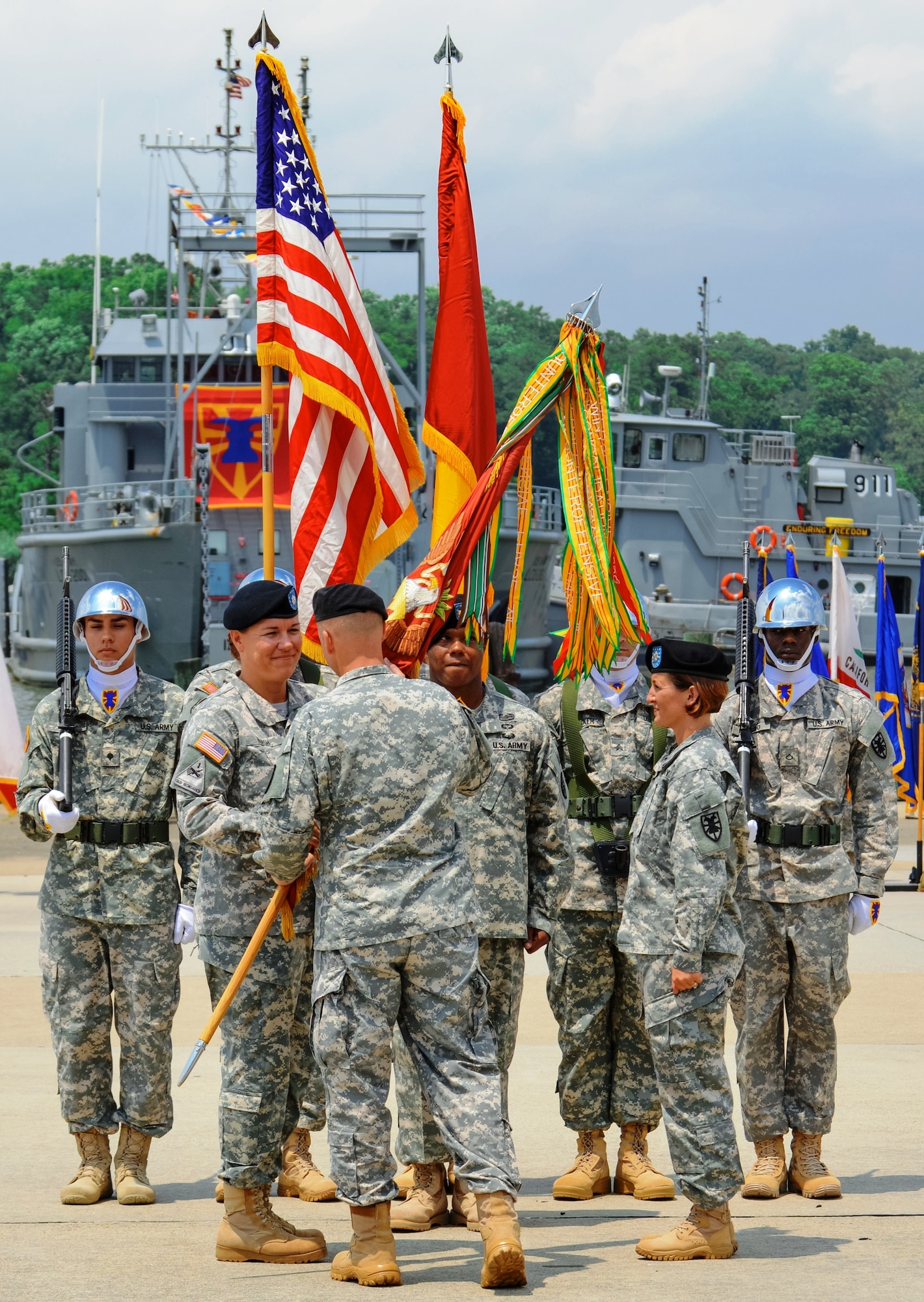 U.S. Army Lt. Col. Kimberly Nash accepts command of 10th Transportation Battalion from Col. Randal Nelson, 7th Transportation Brigade (Expeditionary) commander, during a change of command ceremony held at 3rd Port on Fort Eustis, Va., July 15, 2014.  Lt. Col. Megan Gumpf relinquished command to Nash in a tradition known as the passing of the colors, which symbolizes the passing of authority between commanders.  (U.S. Army photo by Spc. Marian Alleva/Released)