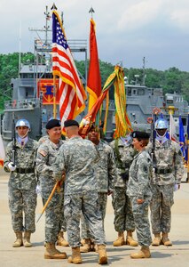 U.S. Army Lt. Col. Kimberly Nash accepts command of 10th Transportation Battalion from Col. Randal Nelson, 7th Transportation Brigade (Expeditionary) commander, during a change of command ceremony held at 3rd Port on Fort Eustis, Va., July 15, 2014.  Lt. Col. Megan Gumpf relinquished command to Nash in a tradition known as the passing of the colors, which symbolizes the passing of authority between commanders.  (U.S. Army photo by Spc. Marian Alleva/Released)
