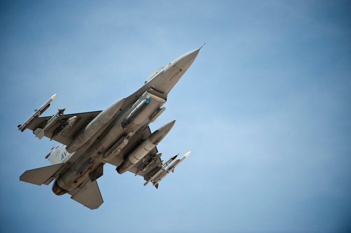 An F-16 Fighting Falcon assigned to the 31st Wing, Aviano Air Base, Italy, passes over the Nellis Air Force Base airfield before landing after a training mission during Red Flag 14-3, July 15, 2014, at Nellis AFB, Nev. Different units from across the Air Force come to Nellis for Red Flag where they receive intense air-to-air combat training. The F-16 is one of the many types of aircraft participating in the exercise. A typical Red Flag includes fighter, bomber, attack, electronic warfare, air superiority, airlift support, search and rescue, and aerial refueling aircraft. (U.S. Air Force photo by Airman 1st Class Thomas Spangler)