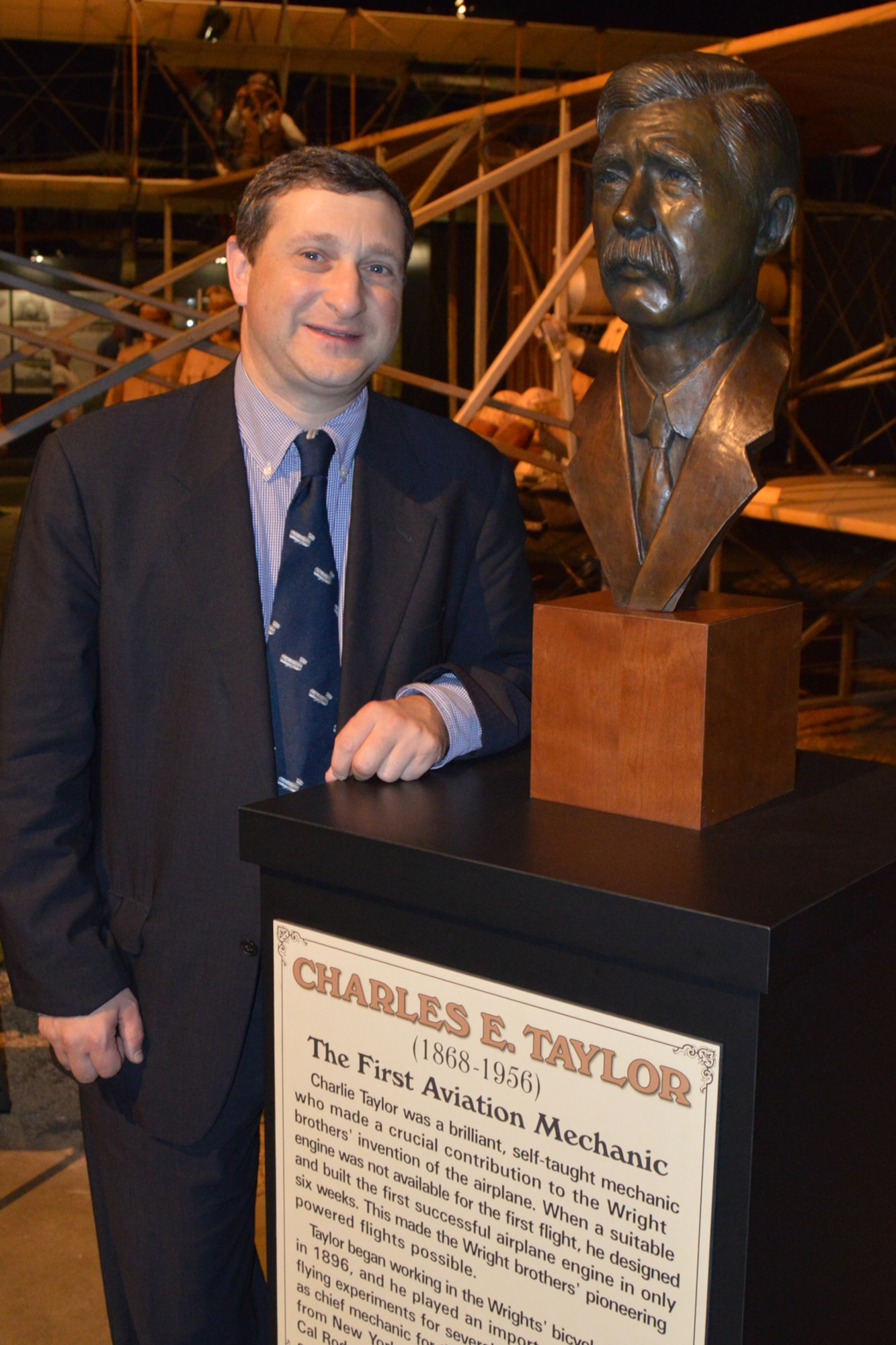 DAYTON, Ohio - Charles Taylor II, great-grandson of Charles E. Taylor, poses next to a bronze bust honoring his grandfather at the National Museum of the U.S. Air Force. Known as the first aviation mechanic, Charles E. Taylor designed and built the engine that made the Wright brothers' pioneering powered flights possible. (U.S. Air Force photo by Ken LaRock) 
