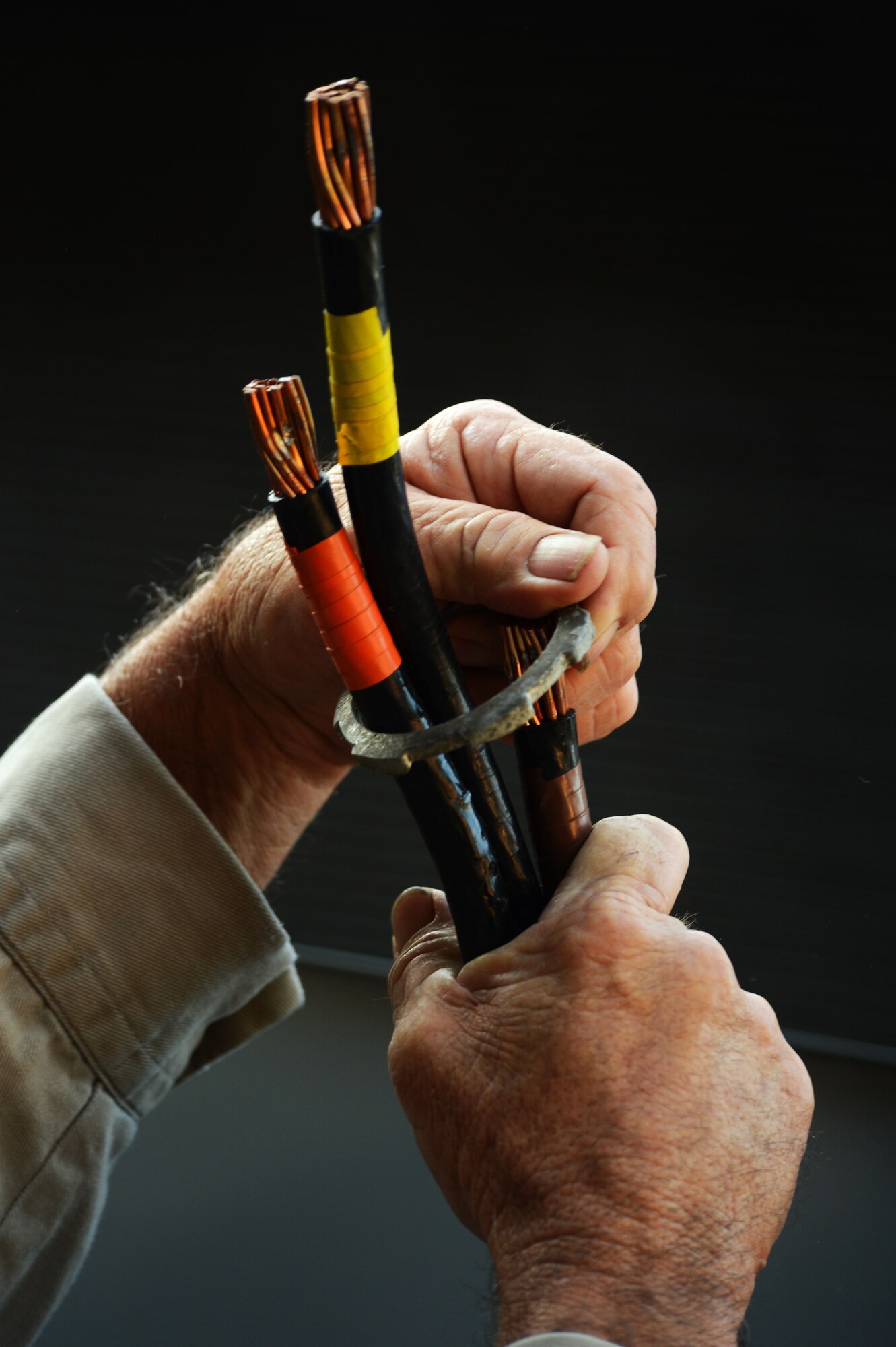 A 20th Civil Engineer Squadron electrical systems worker prepares heavy duty copper wire before installing an electrical panel at Shaw Air Force Base, S.C., July 17, 2014. Before the installation of a new air conditioning unit, the 20th CES electrical systems Airmen prepare a high-voltage electrical panel with the proper wires needed to provide adequate power to the unit. (U.S. Air Force photo by Airman 1st Class Jensen Stidham/Released)