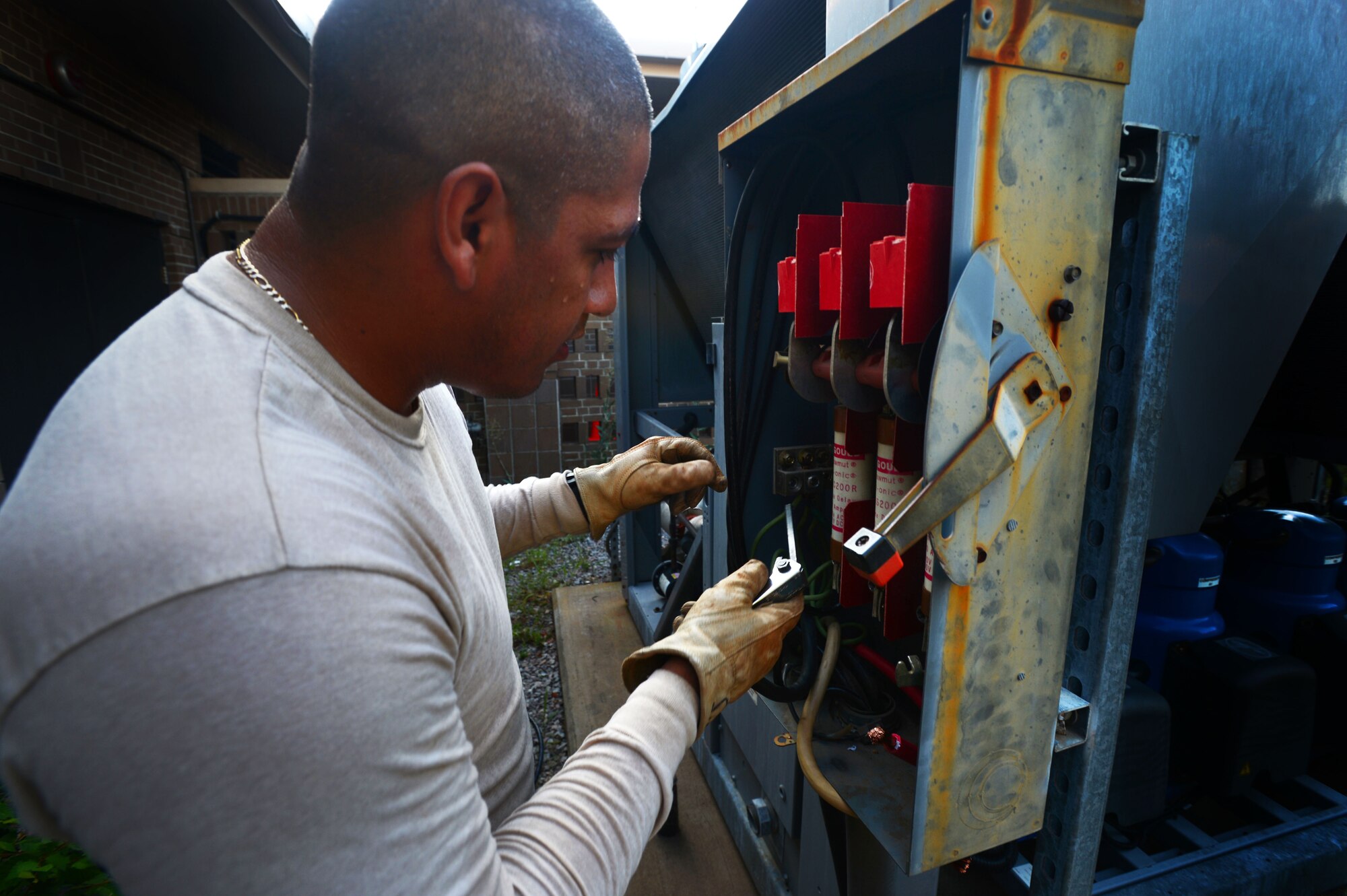 U.S. Air Force Staff Sgt. Carlos Morales, 20th Civil Engineer Squadron electrical systems craftsman, prepares a electrical box for removal at Shaw Air Force Base, S.C., July 17, 2014. Morales, along with several 20th CES electrical systems Airmen, installed a new electrical box to an existing power supply in preparation for an new air conditioning unit. (U.S. Air Force photo by Airman 1st Class Jensen Stidham/Released)