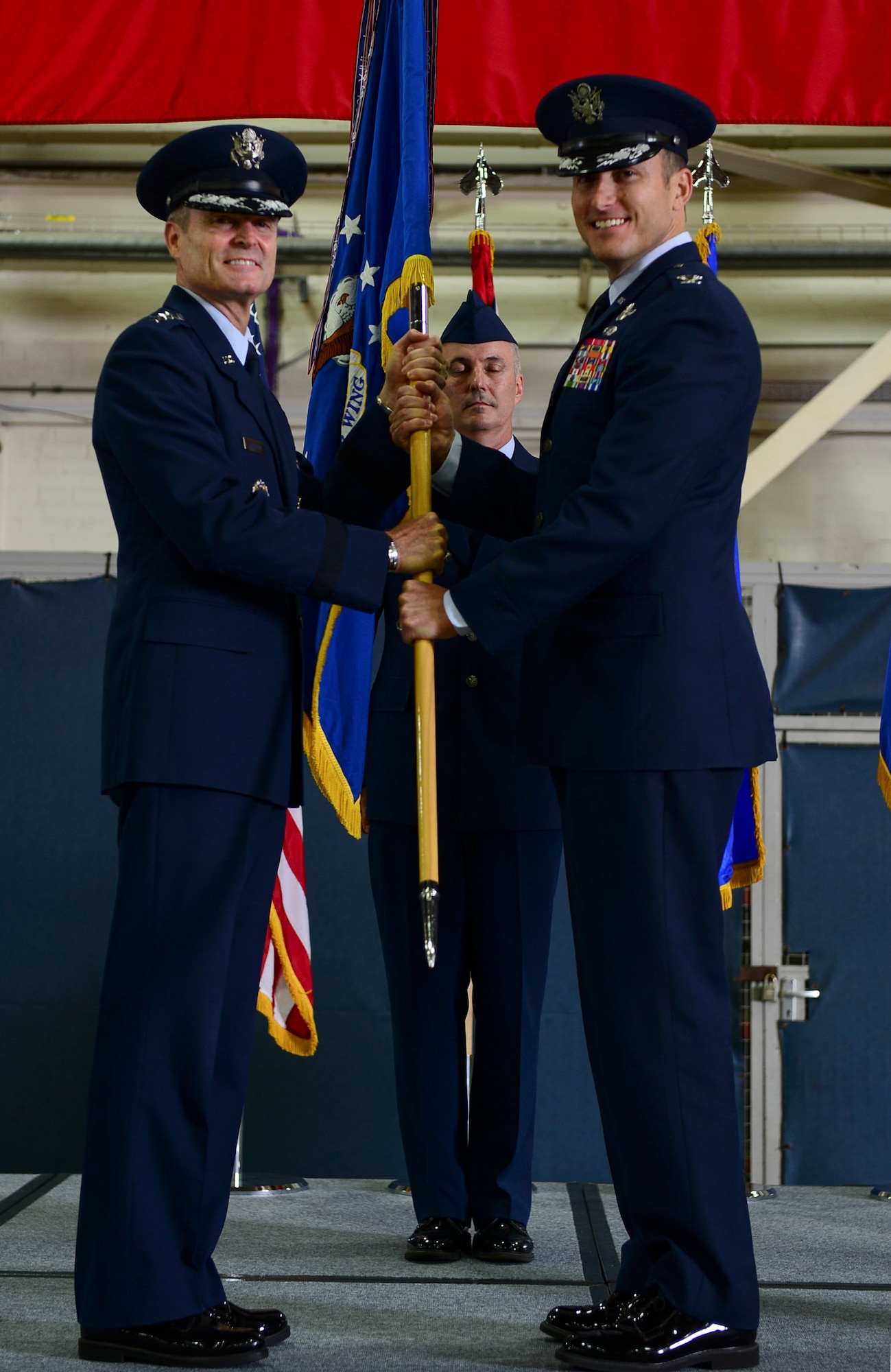 Lt. Gen. Darryl Roberson, 3rd Air Force commander, passes the guidon to Col. Robert Novotny, incoming 48th Fighter Wing commander, during the 48th FW change of command ceremony in Hangar 7 at Royal Air Force Lakenheath, England , July 21, 2014. (U.S. Air Force photo by Airman 1st Class Dawn M. Weber/Released)