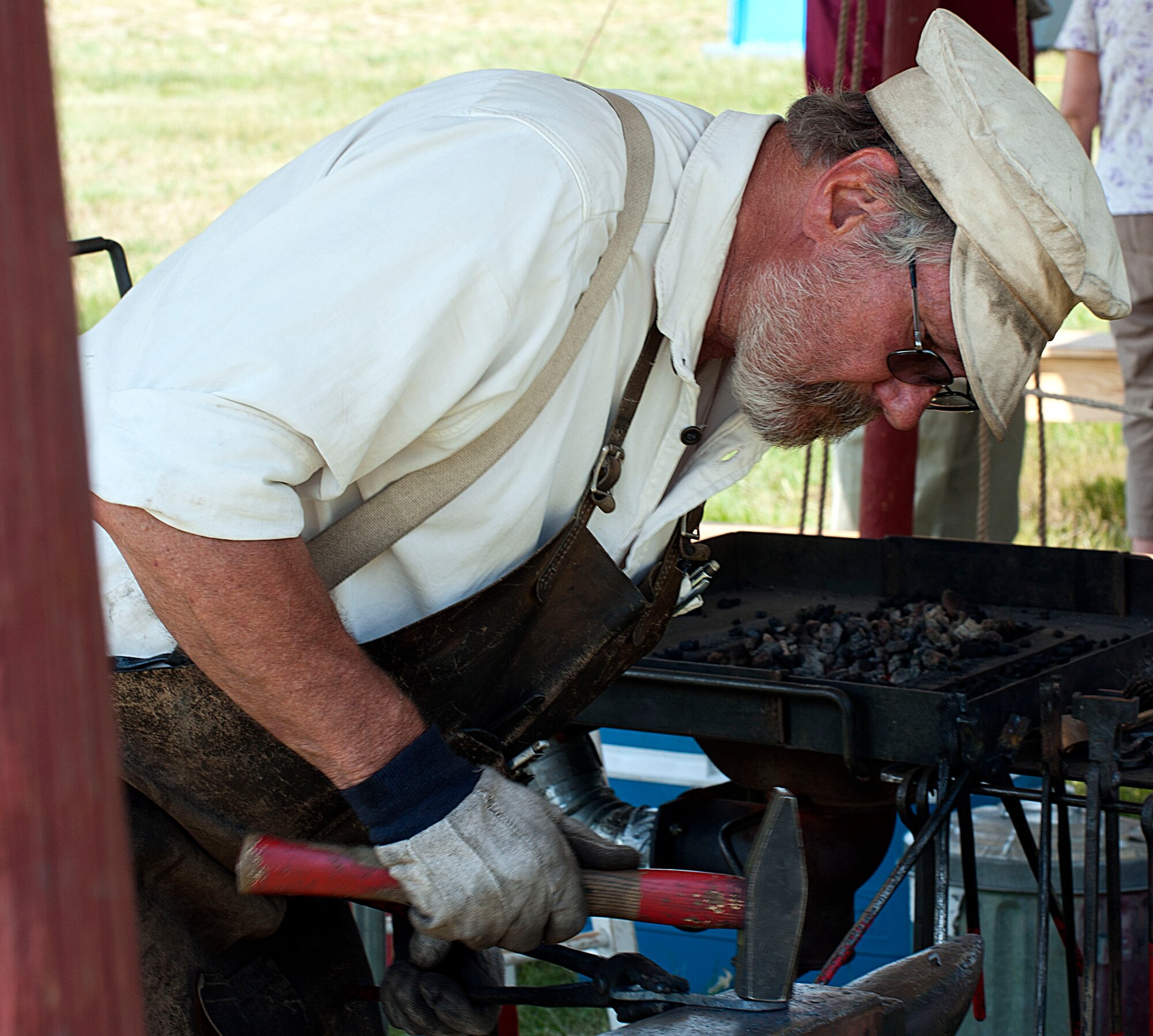 Jan Manning, the local blacksmith, hammers out the kinks in an iron hook July 18 during Fort D.A. Russell Days. Manning has been a part of the base open house for the past 14 years, working as the blacksmith and providing information to audiences about the craft of blacksmithing. (U.S. Air Force photo by Airman 1st Class Brandon Valle)