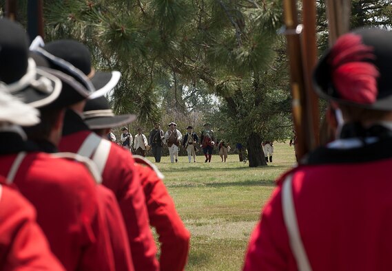 A regiment of British soldiers march on a regiment of patriots during an American Revolutionary War battle re-enactment July 18 as part of Fort D.A. Russell Days, the annual F.E. Warren Air Force Base open house. The re-enactors mimic every detail during their performances, including the drill calls and regiment movements. (U.S. Air Force photo by Airman 1st Class Brandon Valle)