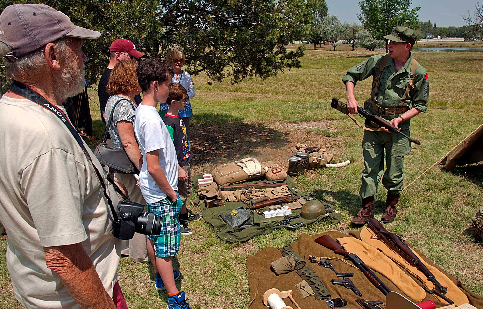 Brandon Ohrns, with the 6th Infantry Division, explains the common tools soldiers used during World War II July 18, 2014, during the annual F.E. Warren Air Force Base open house, Fort D.A. Russell Days. The 6th Infantry Division is represented during the open house because aspects of the unit was stationed at Fort D.A. Russell between 1939 and 1940. (U.S. Air Force photo by Airman 1st Class Brandon Valle)