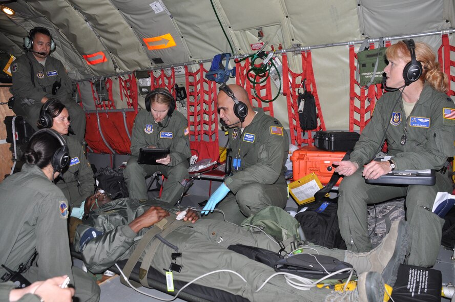 Major Jose Bayron (upper left) evaluates a team of 45 AES members during an in-flight training scenario. In this scenario, an AES member is simulates being a patient strapped to the floor of a KC-135 receiving treatment for altitude sickness. (U.S. Air Force photo by Capt Joe Simms)