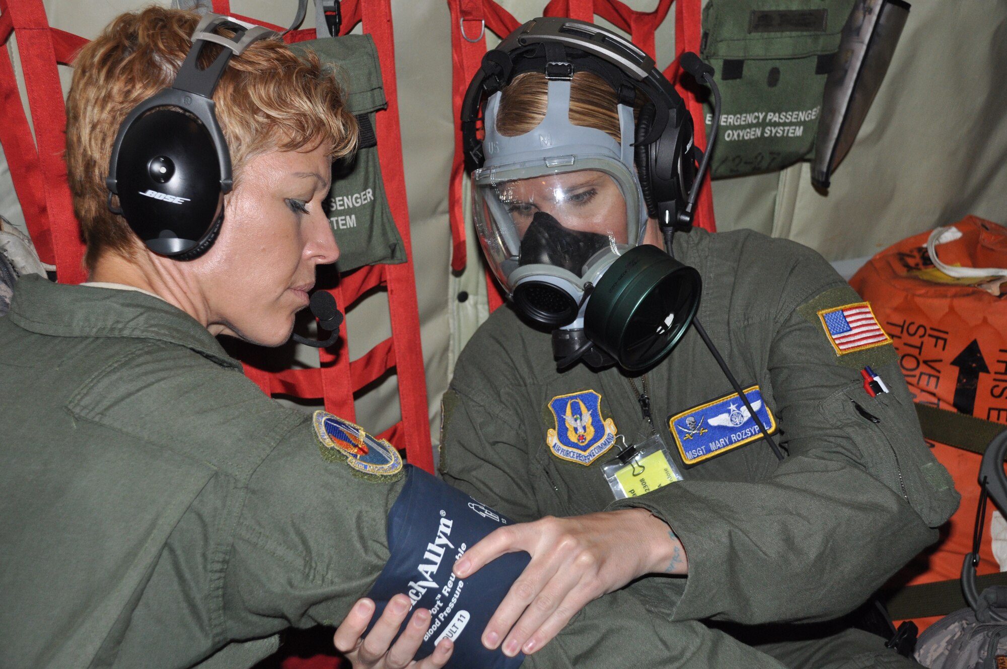 Master Sgt. Mary Rozsypal checks the vital signs of Tech. Sgt. Maria Ayala, during a training mission July 18. AES members are required to complete certain tasks while wearing a gas mask to fulfill their quarterly training requirements. (U.S. Air Force photo by Capt Joe Simms)