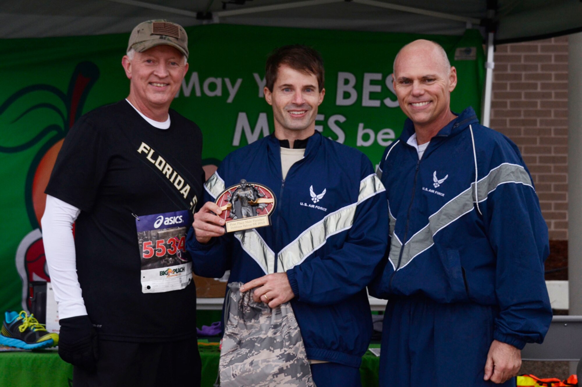 Col. Richard Kemble, 94th Airlift Wing vice commander, and Chief Master Sgt. Wendell Peacock, 94th AW command chief, present Lt. Col. Jeffery Hentz, 700th Airlift Squadron instructor pilot, for being the top male finisher in  the first annual Falcon 5K, a five kilometer fun-run, Dec. 8, 2013. Sponsored by the Dobbins Top 3, proceeds from the event go to the Dobbins Emergency Fund used for assisting Airmen in times of need. (U.S.Air Force photo/Senior Airman Elizabeth Van Patten)