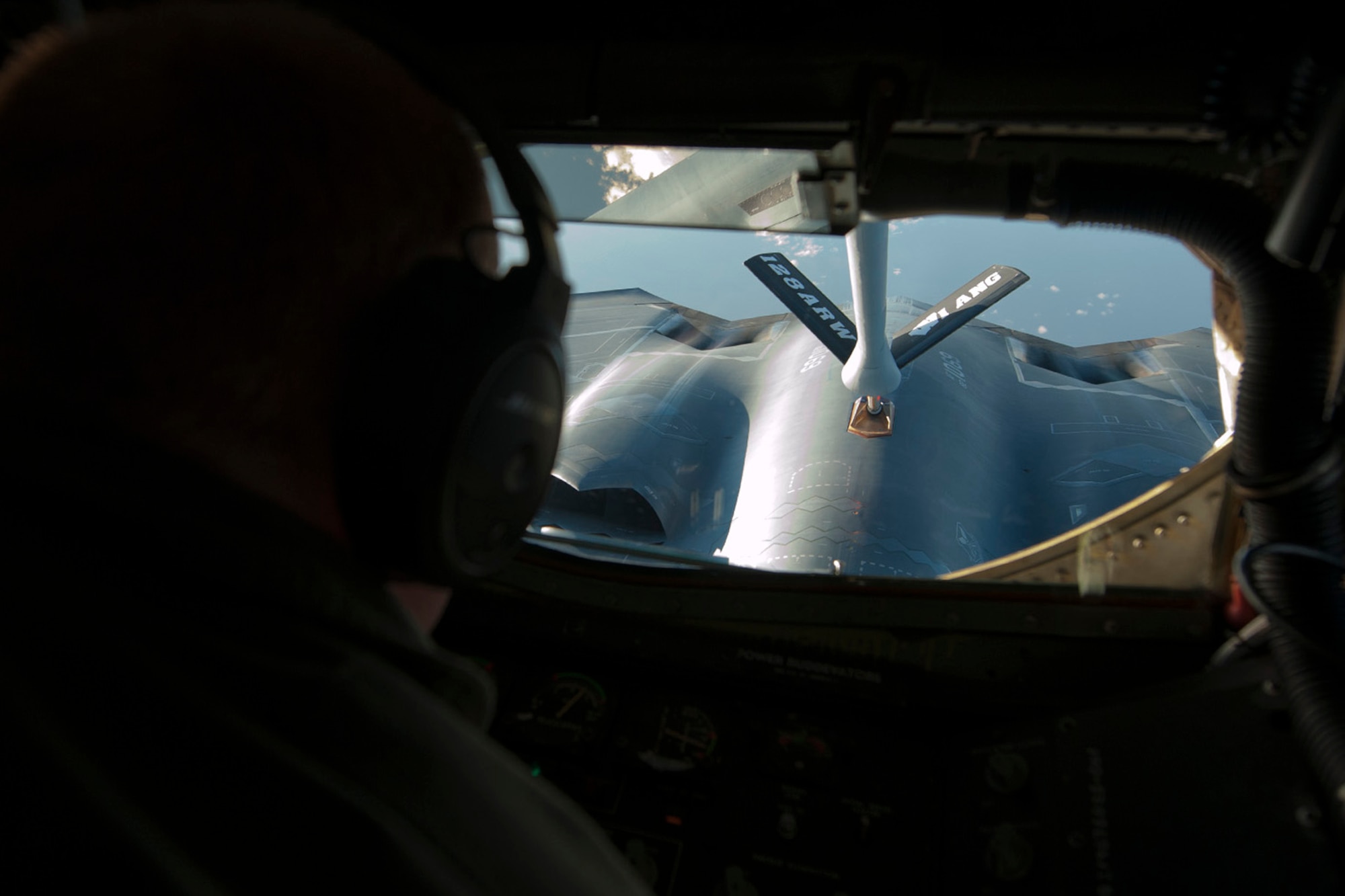 U.S. Air Force Staff Sgt. Brad Love maneuvers the boom of a KC-135R Stratotanker into position to refuel a B-2 Spirit during a refueling mission over the North Atlantic Ocean June 11, 2014. The B-2s are conducting training flights and regional familiarization in the U.S. European Command area of operations. Love is a boom operator with the 126th Air Refueling Squadron of the Wisconsin Air National Guard. The B-2 is a multi-role bomber capable of delivering both conventional and nuclear munitions. (U.S. Air Force photo by Tech. Sgt. Paul Villanueva II/Released)