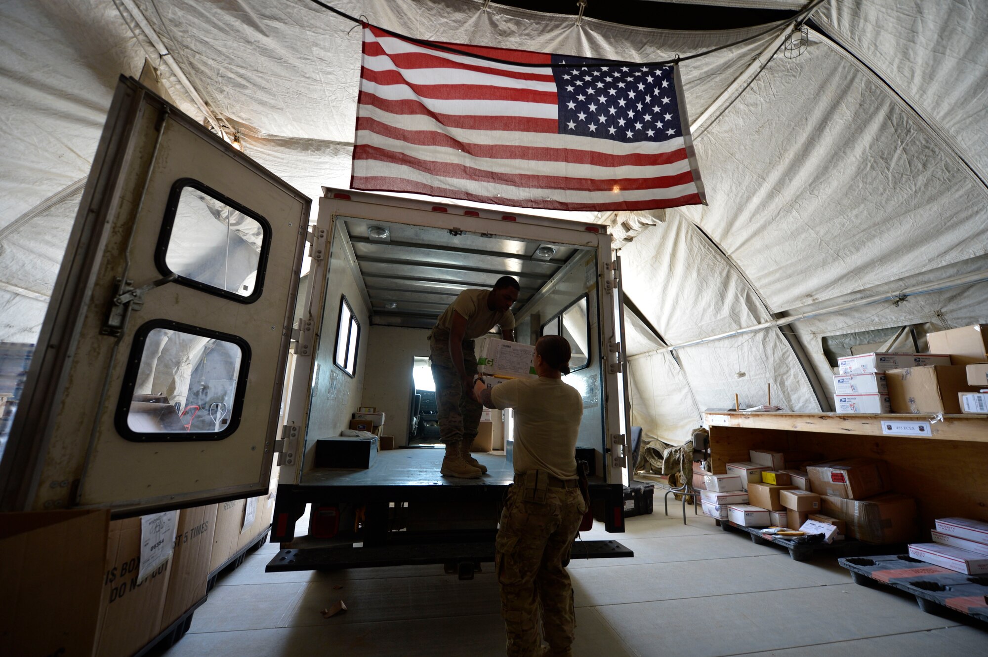 (From left)U.S. Air Force Senior Airmen Lorenza Kates and Victoria Hill, 455th Expeditionary Communications Squadron mail clerks load a truck with mail at Bagram Airfield, Afghanistan June 26, 2014.  Kates and Hill are responsible for handling mail for Airmen in the 455th Air Expeditionary Wing.  They handle thousands of packages and letters per month.  Kates is deployed from Davis Monthan Air Force Base, Ariz. and a native of Dublin, Ga. Hill is deployed from Whiteman Air Force Base, Mo. and a native of Blanchard, La.  (U.S. Air Force photo by Staff Sgt. Evelyn Chavez)