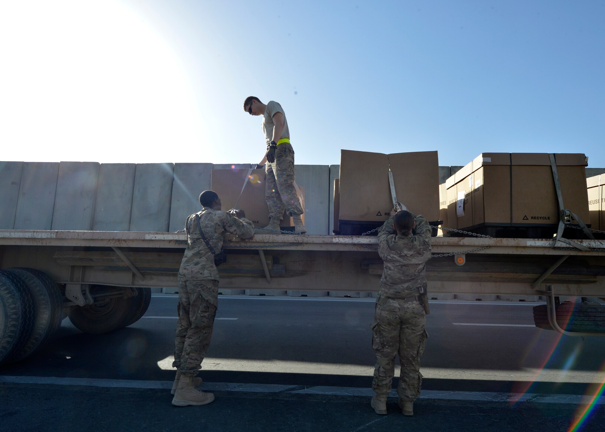 (From left) U.S. Air Force Senior Airman Lorenza Kates, 455th Expeditionary Communications Squadron mail clerk, Airman 1st Class Joshua Zehms, 455th Expeditionary Logistics Readiness Squadron vehicle operations and Senior Airman  Victoria Hill, 455 ECS mail clerk load a flatbed truck at Bagram Airfield, Afghanistan June 26, 2014.  Hill and Kates are responsible for delivering mail to Airmen assigned to the 455th Air Expeditionary Wing.  They average 77 pallets of mail per week that amounts to approximately to 38,500 pounds.  Kates is deployed from Davis Monthan Air Force Base, Ariz. and a native of Dublin, Ga. Zehms is deployed from Nellis Air Force Base, Nev. and a native of Pittsburgh, Pa.  Hill is deployed from Whiteman Air Force Base, Mo. and a native of Blanchard, La. (U.S. Air Force photo by Staff Sgt. Evelyn Chavez/Released)