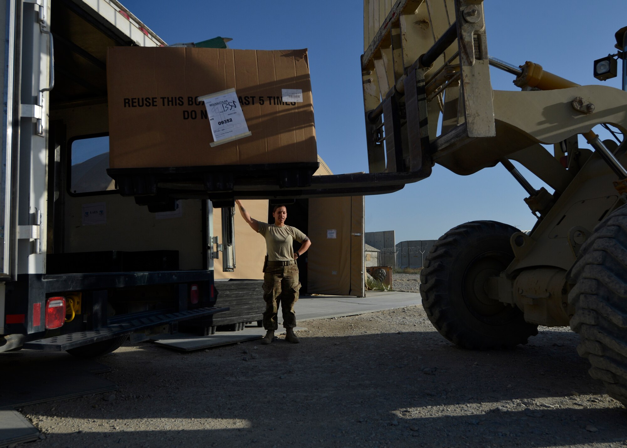 U.S. Air Force Senior Airman Victoria Hill, 455th Expeditionary Communications Squadron mail clerk, directs a forklift with a pallet of mail at Bagram Airfield, Afghanistan June 26, 2014.  Hill is responsible for delivering mail to all Airmen in the 455th Expeditionary Wing.  She is deployed from Whiteman Air Force Base, Mo. and a native of Blanchard, La. (U.S. Air Force photo by Staff Sgt. Evelyn Chavez/Released)