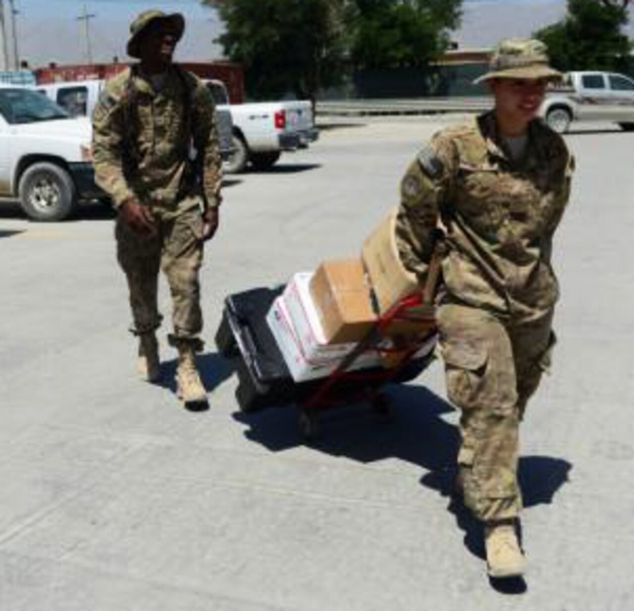 Air Force Senior Airman Lorenza Kates, left, and Senior Airman Victoria Hill, 455th Expeditionary Communications Squadron mail clerks, deliver mail at Bagram Air Field, Afghanistan, June 26, 2014. Kates and Hill are responsible for handling mail for airmen in the 455th Air Expeditionary Wing. The duo handles thousands of packages and letters each month. U.S. Air Force photo by Staff Sgt. Evelyn Chavez