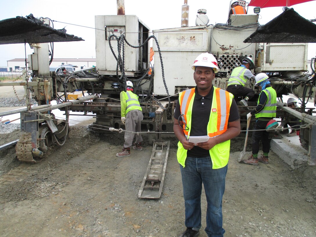 Tony Morgan, advancing minorities in engineering program intern, observes a slip form paver, used to separate and smooth out wet concrete until it dries into place, at U.S. Army Garrison Humphreys. 