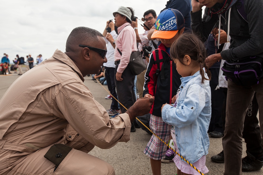 Staff Sgt. Shival Ramroop, an airframes hydraulic mechanic with Marine Medium Tiltrotor Squadron 262, and a native of Bogota, New Jersey, gives stickers to children as part of the Sapporo Air Show at Sapporo Okadama Airport, July 20, 2014. More than 50,000 spectators viewed U.S. and Japan military and commercial aircraft that were either on static display or showcased flying over the airport. “It is a great opportunity, not only for the United States military, but also for the Japan military to showcase their aircraft. We want to show the Japanese public what we do and why our alliance is so important,” said Maj. Gen. Andrew W. O’Donnell Jr., the deputy commander of United States Forces, Japan. This is the first time the Osprey has flown to Sapporo. The pilots and crew of the Osprey are with VMM-262, 31st Marine Expeditionary Unit, III Marine Expeditionary Force.
