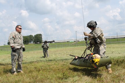 Staff Sgt. Dave Palmer, a Georgia Guard member with Detachment 1, Charlie Company, 1-111th General Support Aviation Battalion, supervises Staff Sgt. Travis Vanzo as he prepares to be hoisted up to a UH-60M Blackhawk helicopter in Marietta, Georgia, on July 13, 2014 as part of proficiency training.
 