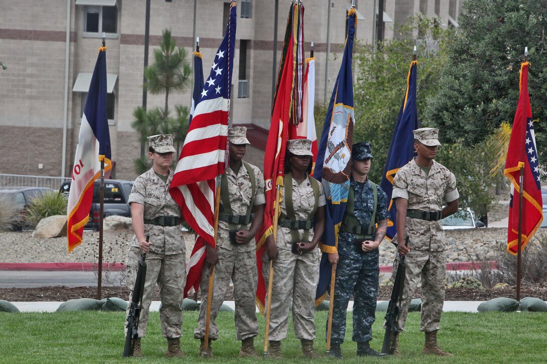 Four Marines and one sailor with 1st Marine Logistics Group color guard stand at parade rest during a battle colors anniversary ceremony in honor of the unit’s 67 years of dedicated service aboard Camp Pendleton, Calif., July 15, 2014.