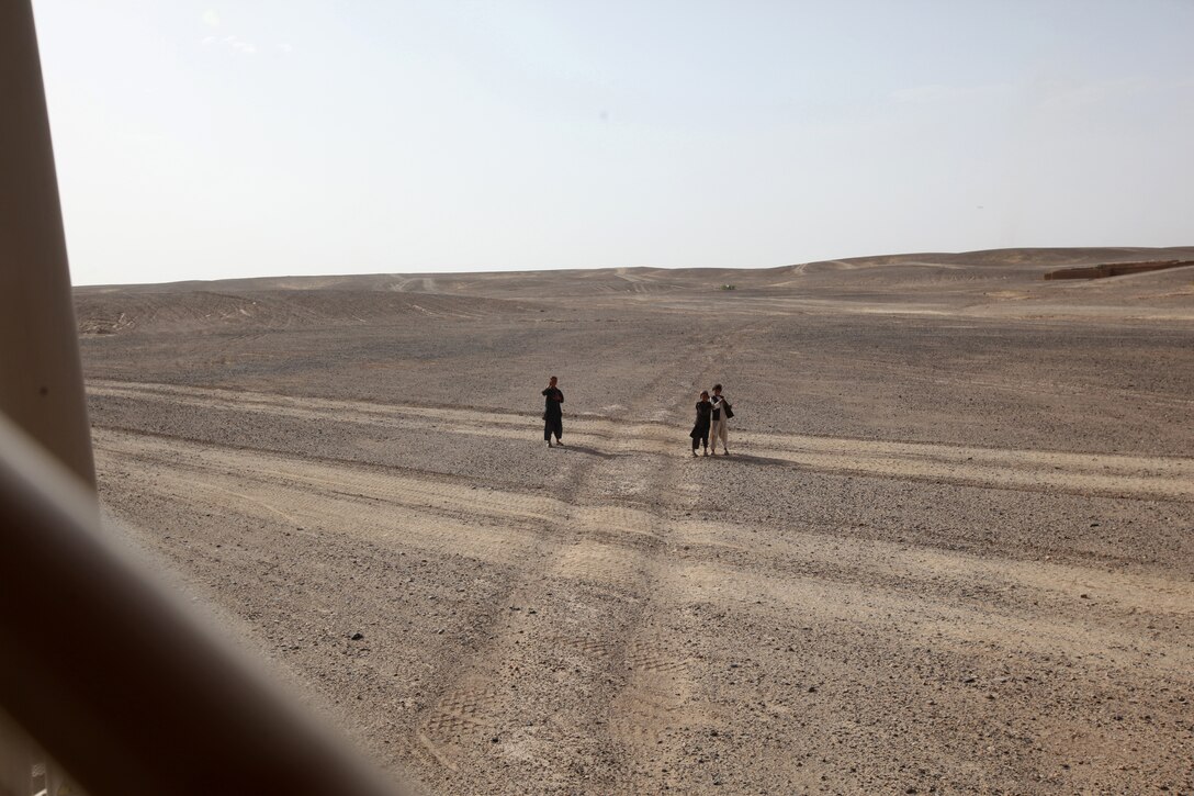 Afghan children wave and watch as a combat logistics patrol passes them in Helmand province, Afghanistan, July 14, 2014. The turret gunners with CLB-7 act as the eyes and ears while being the guardian angels of each combat logistics patrol conducted during their deployment.