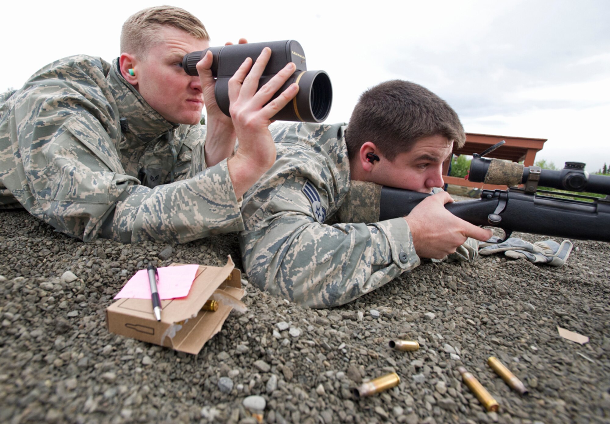 Senior Airman Aric Shott, left, uses a spotting scope to assist Senior Airman Austin Cavenaugh as they train with the M24 Sniper Weapon System July 11, 2014, at Joint Base Elmendorf-Richardson, Alaska. The M24 is a military version of the Remington Model 700, a 7.62 mm rifle, and has been in service with the U.S. military since 1988. Both Airmen are assigned to assigned to the 673rd Security Forces Squadron. Shott is a a native of West Palm Beach, Fla. Cavenaugh is a native of Beulaville, N.C. (U.S. Air Force photo/Justin Connaher)
