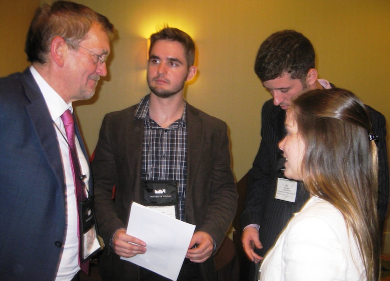 (L) Attendee talks to students from University of Santa Catarina in Brazil, Yuri Triska, Belisa Speranzini and Samual Haurelhuk.