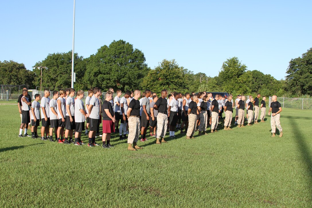 Staff Sgt. Franky Rodriguez, station commander of Recruiting Substation Kissimmee, prepares to lead Marines and football players in a dynamic warm up at St. Cloud High School, St. Cloud, Fl, July 22, 2014. Football players learned about leadership principals and traits while exercising with Marines.  