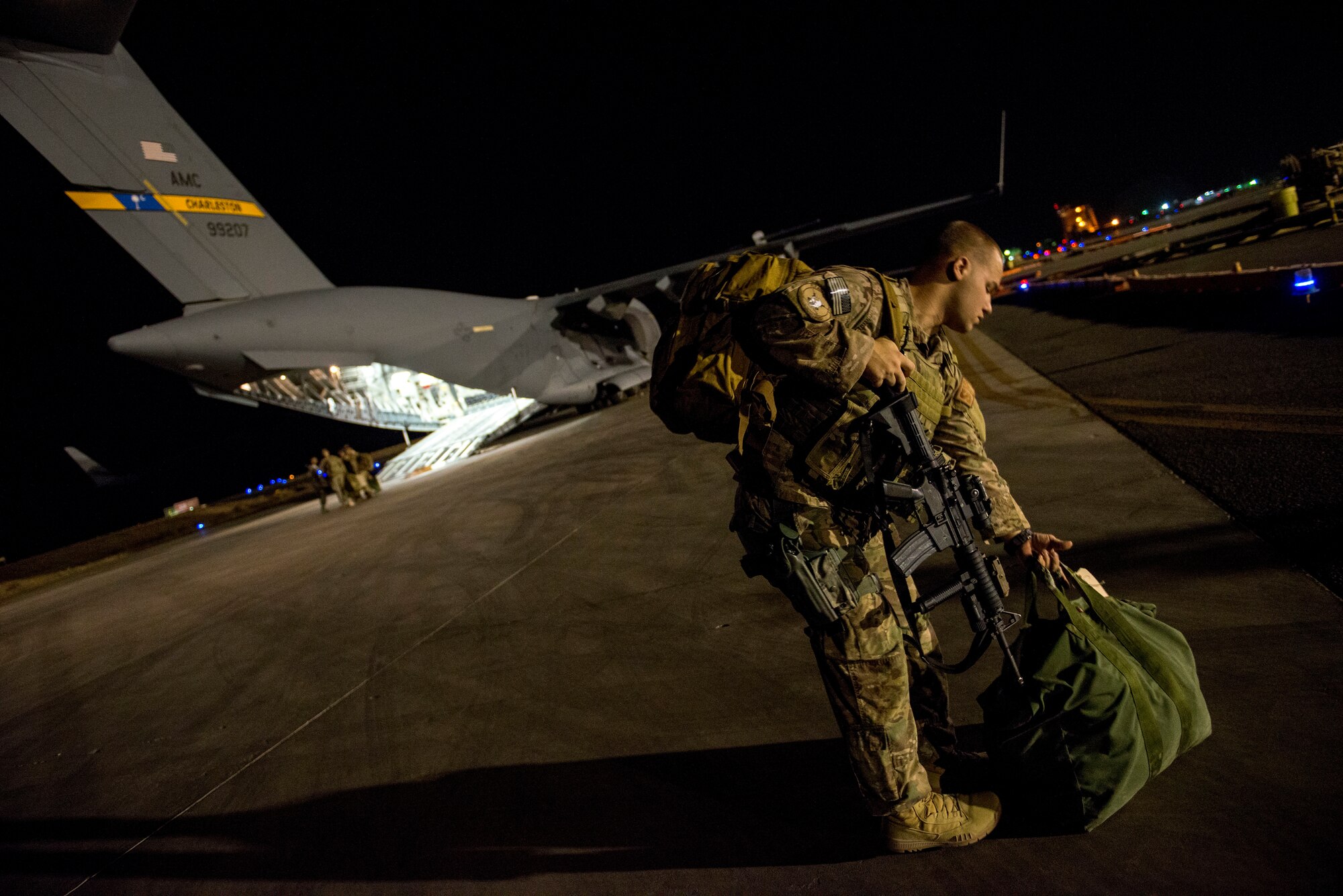 Airman 1st Class Marc Francesconi loads his gear in preparation for takeoff in a C-17 Globemaster III June 29, 2014, in Southwest Asia. Francesconi is a member of the 386th Expeditionary Security Forces Squadron fly away security team. Security forces members provide security of personnel and aircraft around the world. (U.S. Air Force photo/Staff Sgt. Jeremy Bowcock)