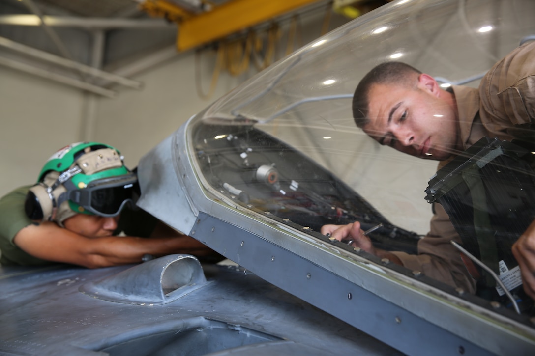 Lance Cpl. Michael Villamiel, left, assists Sgt. Stuart Vonderheide remove an AV-8B Harrier canopy at Marine Corps Air Station Cherry Point, N.C., July 17, 2014. Marine Attack Training Squadron 203 trains Harrier pilots before they join an operational squadron.  Vonderheide and Villamiel are both ejection seat mechanics with VMAT-203.  