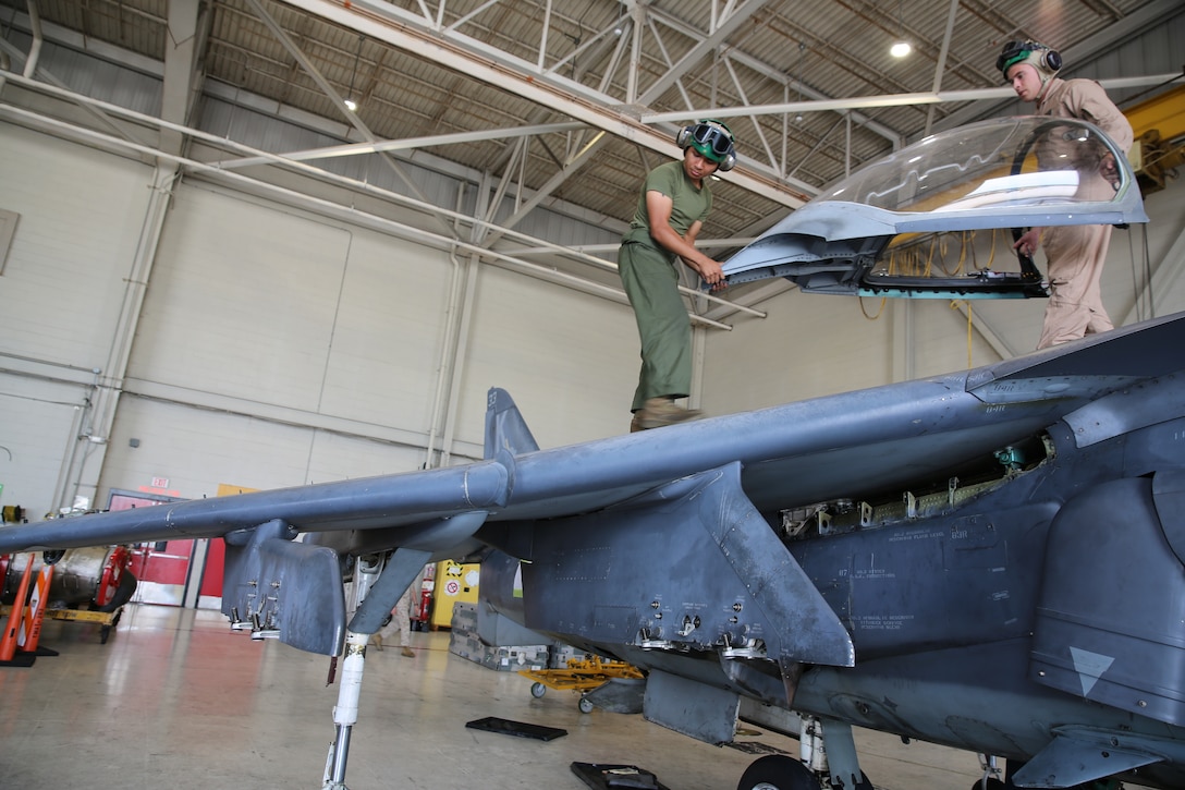 Lance Cpl. Michael Villamiel, left, and Sgt. Stuart Vonderheide remove an AV-8B Harrier canopy at Marine Corps Air Station Cherry Point, N.C., July 17, 2014. Ejection seat mechanics specialize in the repair, replacement and removal of ejection seats, canopies and the Harrier’s environmental control system. Vonderheide and Villamiel are both ejection seat mechanics with Marine Attack Training Squadron 203. 