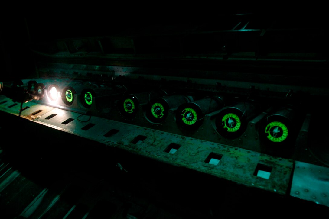 Marines with Marine Aerial Refueling Transportation Squadron 352 do a final timer check before dropping flares from a KC-130J during a battlefield illumination mission July 18, 2014. Battlefield illumination missions are implemented to light up areas in support of nighttime coalition operations within Regional Command (Southwest). (U.S. Marine Corps Photo by: Sgt. Frances Johnson/Released)