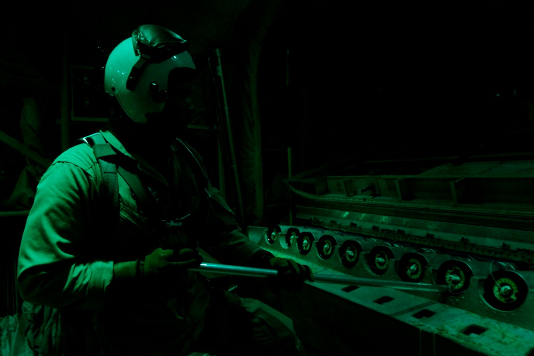 Staff Sgt. Ramon Rodriguez, a KC-130J crew chief with Marine Aerial Refueling Transportation Squadron 352, stands ready to push flares from a KC-130J during a battlefield illumination mission July 18, 2014. Battlefield illumination missions are implemented to light up areas in support of nighttime coalition operations within Regional Command (Southwest). (U.S. Marine Corps Photo by: Sgt. Frances Johnson/Released)