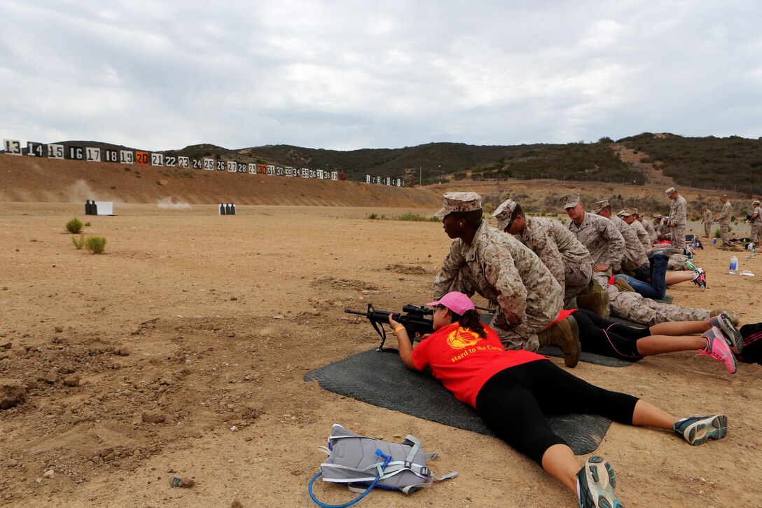 Marine Aircraft Group (MAG) 11 spouses fire the M4 service rifle during a Jane Wayne Day aboard Marine Corps Air Station Miramar, Calif., July 19. The spouses were able to keep their targets as a souvenir when they completed firing. 