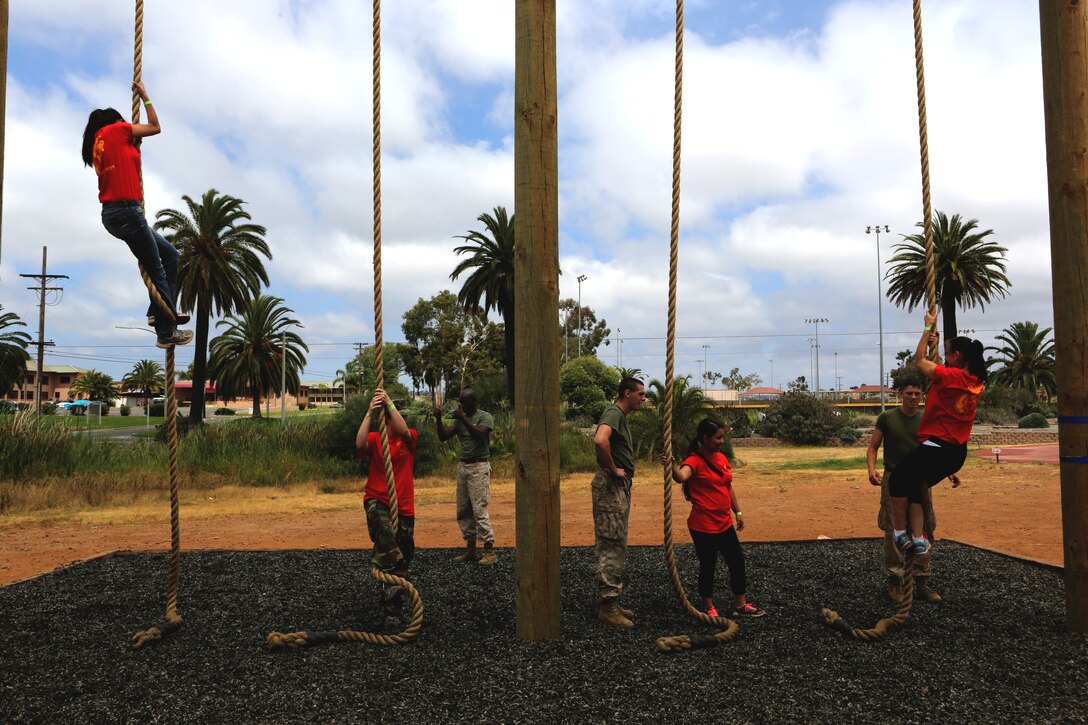 Spouses with Marine Aircraft Group (MAG) 11 climb ropes during an obstacle course demonstration during a Jane Wayne Day aboard Marine Corps Air Station Miramar, Calif., July 19. The spouses also fired the M4 service rifle at Carlos Hathcock Range aboard the air station and viewed static displays of multiple aircraft.