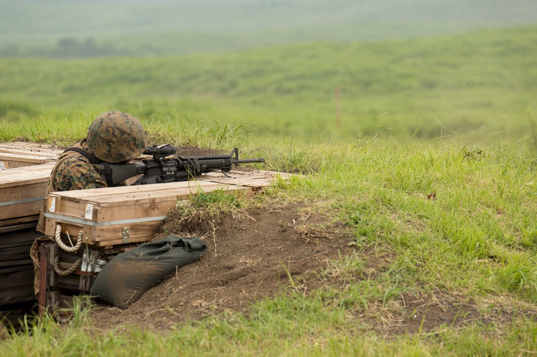 Lance Cpl. Mitchell Jameson, a personal computer/telephone systems intermediate repairman with Combat Logistics Company 36, takes cover and fires his M-16A4 service rifle while conducting squad movements and live fire training during Exercise Dragon Fire 2014 at Combined Arms Training Center Camp Fuji, Japan, July 17. Dragon Fire is CLC-36’s annual Battle Skills Training exercise that focuses on improving the individual and collective combat skills of CLC-36 service members with an emphasis on weapons familiarization training.  