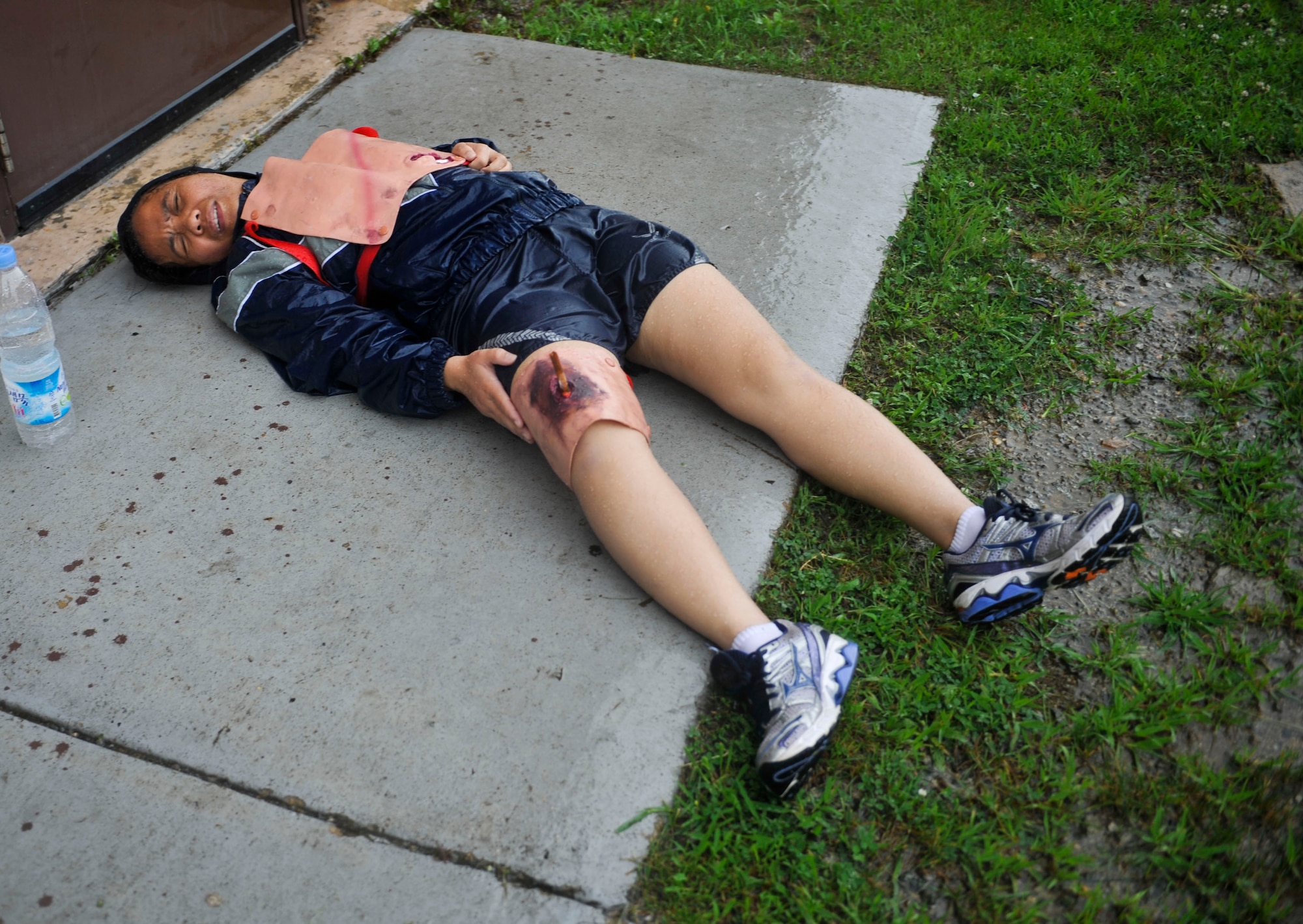 An Airman lies on the ground with simulated injuries during the simulated aircraft mishap on Osan Air Base, July 23, 2014. The simulated mishap took place to ensure Airmen are ready to handle an emergency management scenario in a real world situation. (U.S. Air Force photo by Senior Airman David Owsianka)
