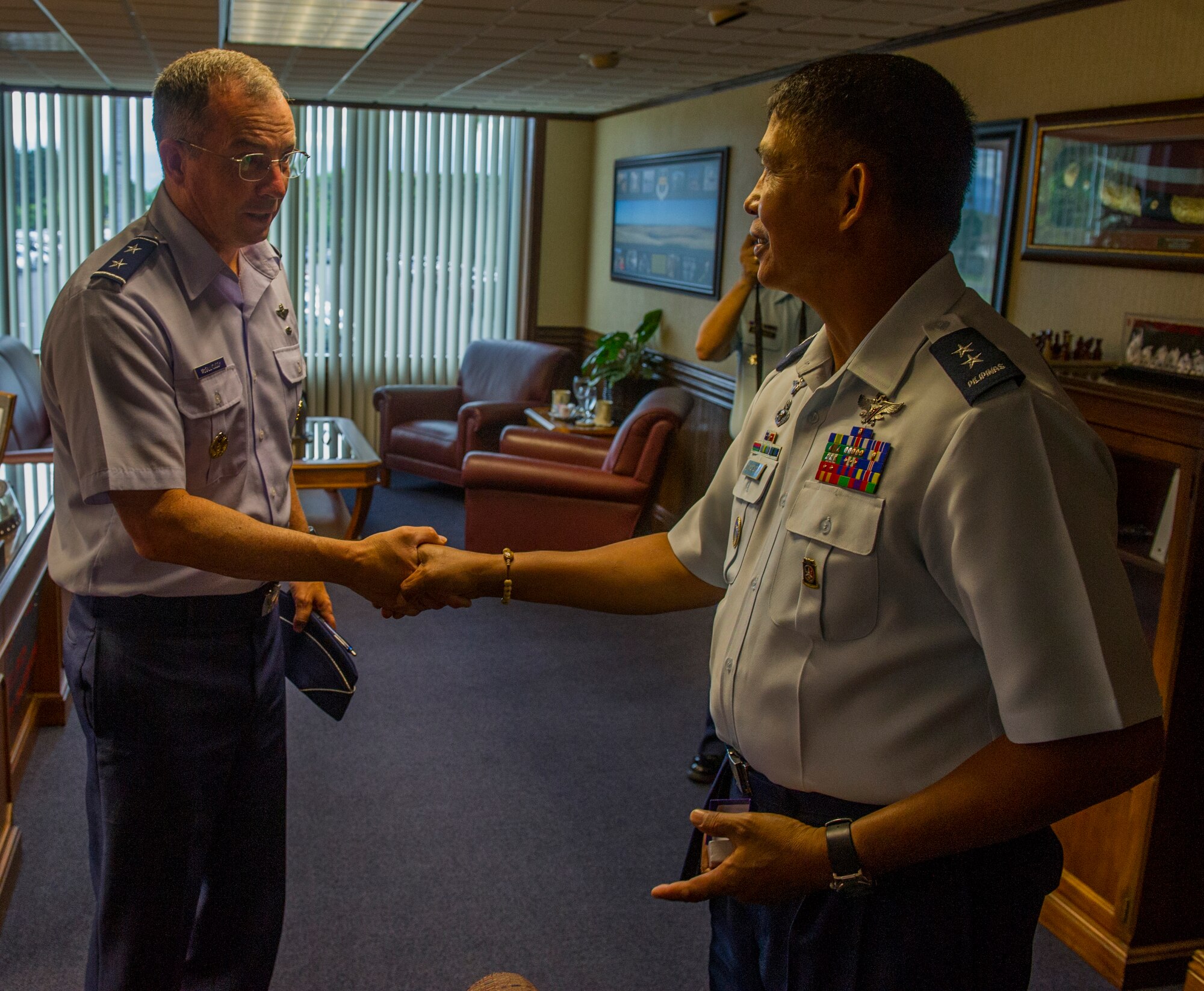 Maj. Gen. Paul McGillicuddy, Pacific Air Forces vice commander (left), exchanges coins with Philippine Air Force Maj. Gen. Raul Dimatatac, PAF Headquarters Air Education and Training commander, at the PACAF headquarters building July 22, 2014 on Joint Base Pearl Harbor-Hickam, Hawaii. During the PAF delegation's visit, PACAF and Philippine Air Force leaders conducted Airmen-to-Airmen talks in an effort to solidify partnerships between the two forces. (U.S. Air Force photo by Staff Sgt. Nathan Allen/Released)