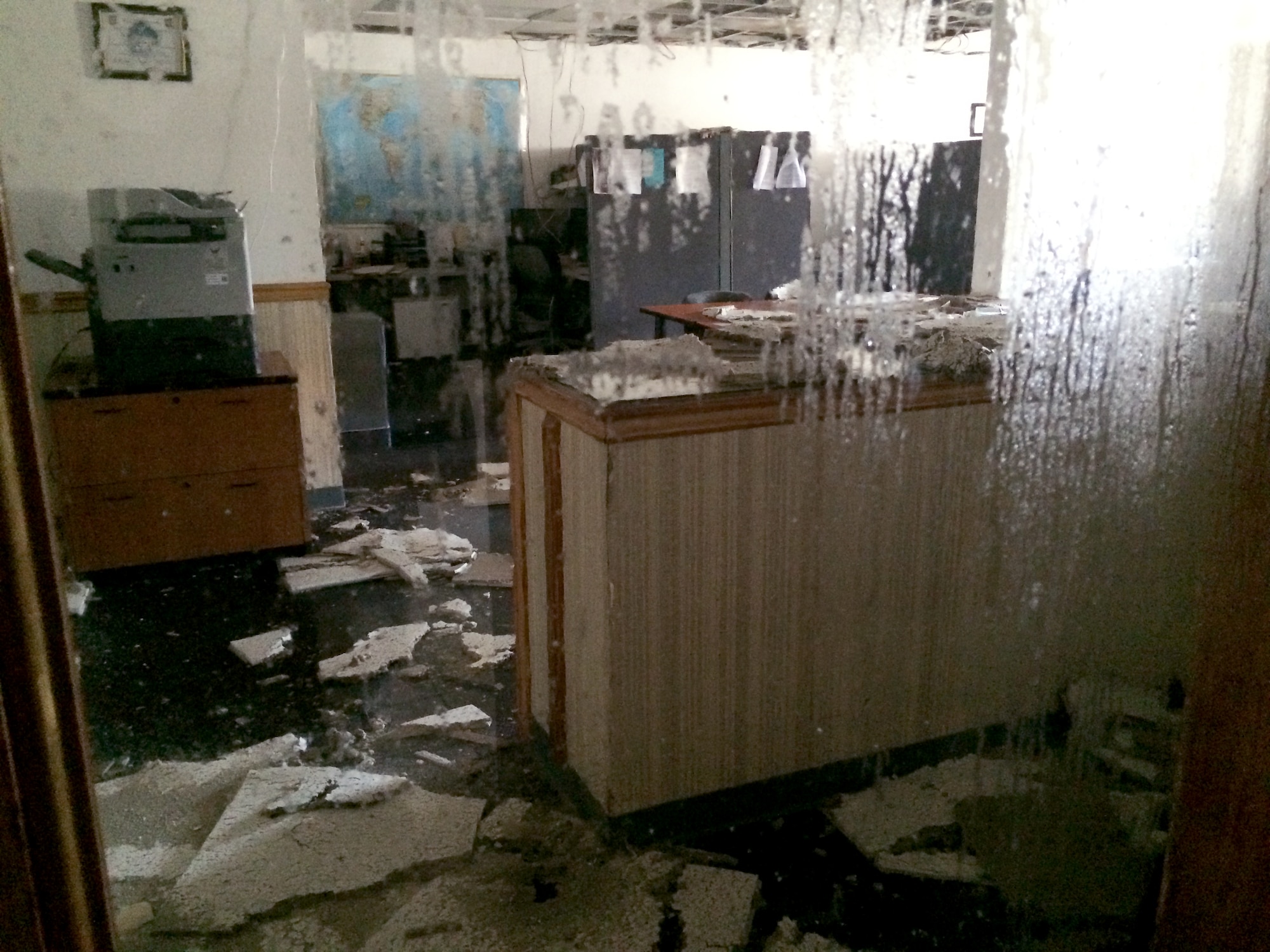 Water pours in through the ceiling of an office in the 355th Logistics Readiness Squadron customer service building at Davis-Monthan Air Force Base, Ariz., July 14, 2014. The flooding of the building was a result of the monsoon storm that swept through D-M July 13. (Courtesy photo)