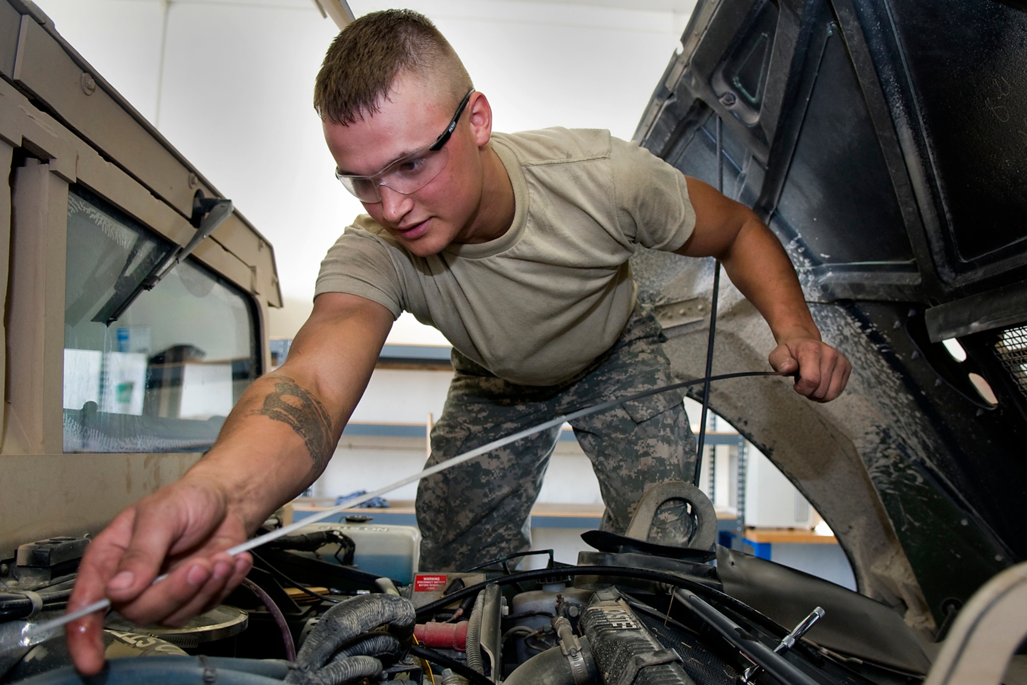 U.S. Army Spc. Stephen Thomson, 316th Psychological Operations Company wheeled vehicle mechanic, performs maintenance on a Humvee at Camp Atterbury Joint Maneuver Training Center, Ind., June 19, 2014. More than 30 PSYOP Soldiers from Grissom Air Reserve Base, Ind., took part in an intensive military support operations training at Camp Atterbury. (U.S. Air Force photo/Tech. Sgt. Mark R. W. Orders-Woempner)
