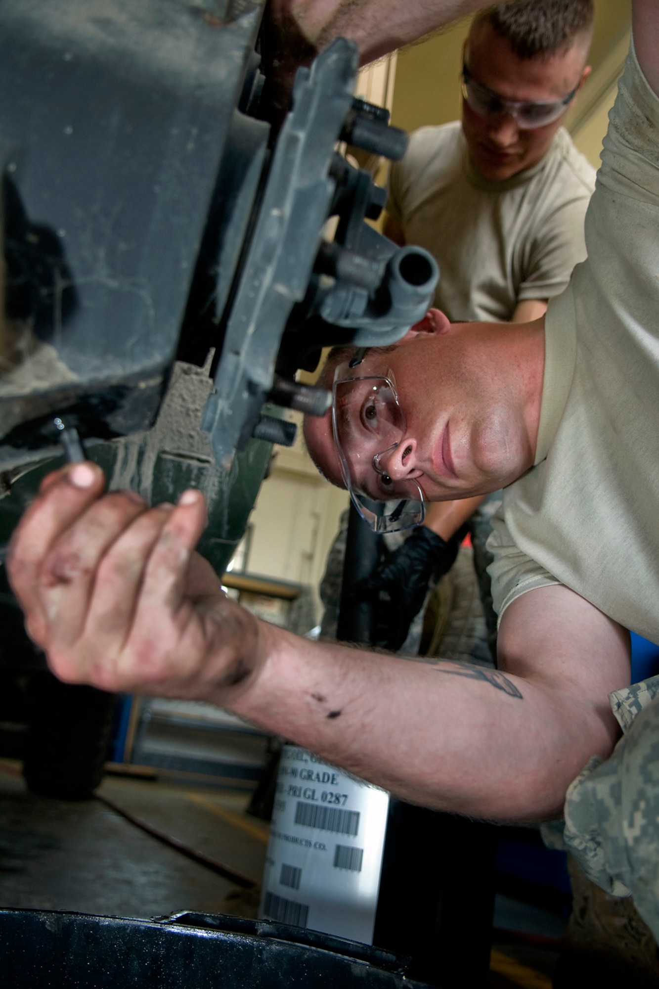 U.S. Army Spcs. James Blood, lower, and Stephen Thomson, 316th Psychological Operations Company wheeled vehicle mechanics, perform maintenance on a Humvee at Camp Atterbury Joint Maneuver Training Center, Ind., June 19, 2014. More than 30 PSYOP Soldiers from Grissom Air Reserve Base, Ind., took part in an intensive military support operations training at Camp Atterbury. (U.S. Air Force photo/Tech. Sgt. Mark R. W. Orders-Woempner)
