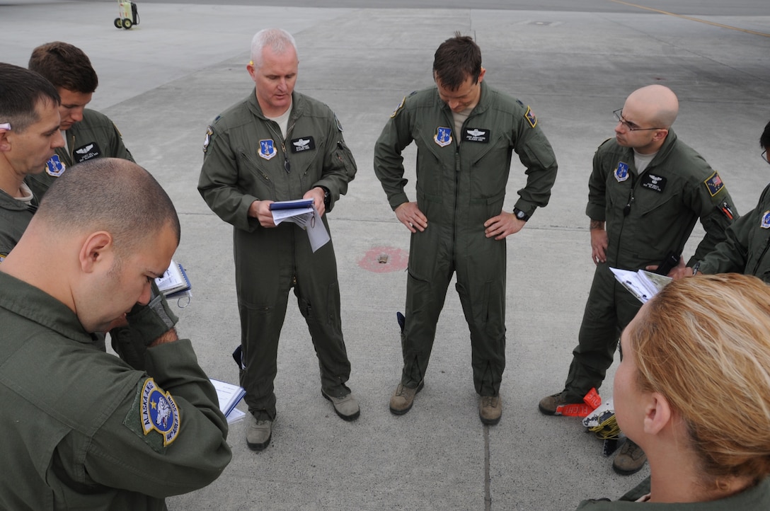 Aircrew members from the Alaska Air National Guard’s 144th Airlift Squadron hold a final briefing prior to take-off here for an airdrop as part of a six-day Joint Forcible Entry Exercise on June 7, 2014. The JFEX was a joint effort between active duty Army, Air Force and Air National Guard units from Alaska, Washington and Guam. (Air Force photo by Staff Sgt. William Banton)
