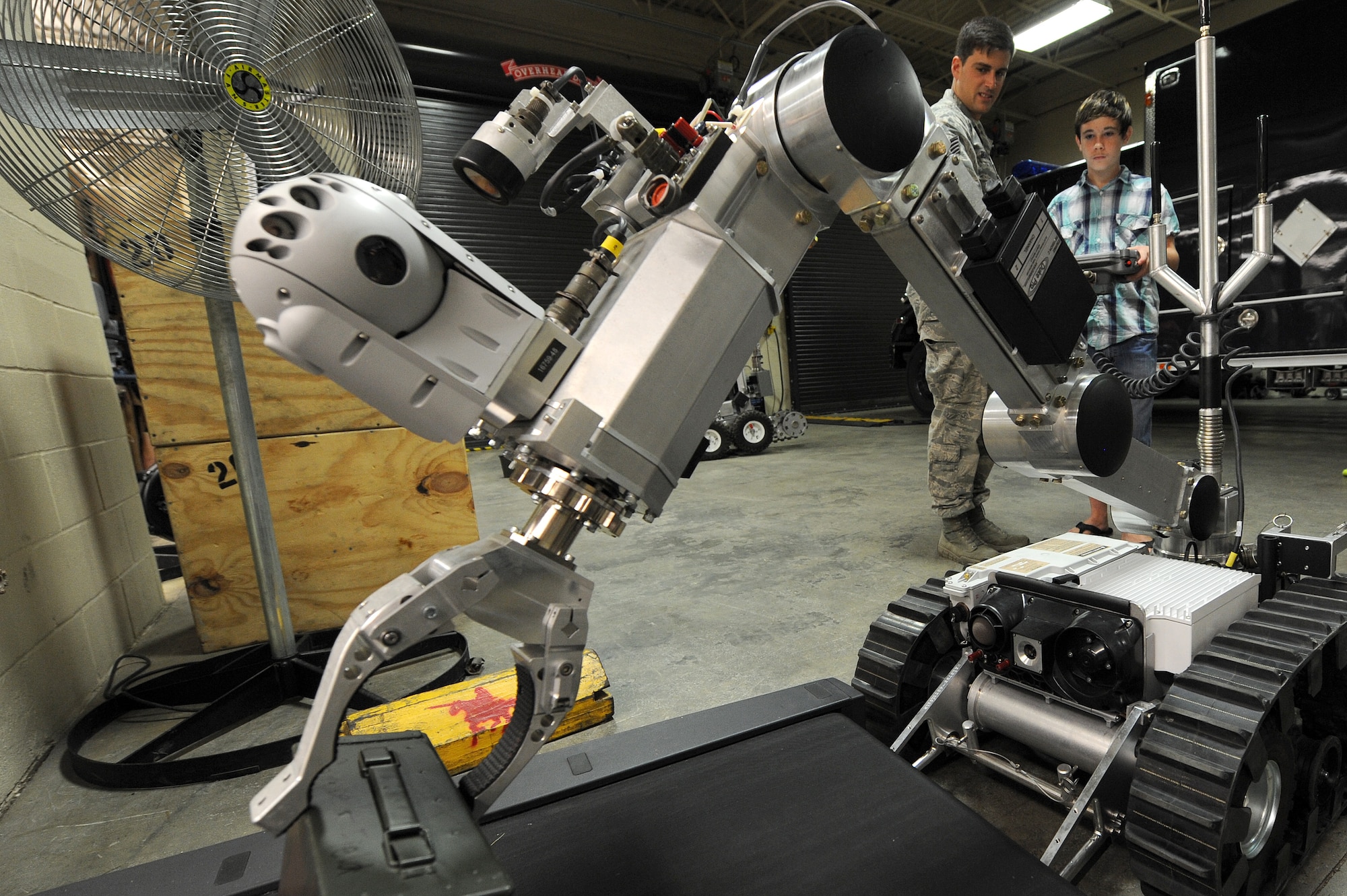Staff Sgt. Justin Beasley, 4th Civil Engineer Squadron explosive ordnance disposal journeyman, teaches a Team Seymour member to control an EOD robot July 21, 2014, at Seymour Johnson Air Force Base, North Carolina. Airmen of the 4th CES EOD shop demonstrated practical applications of robotics in the military. (U.S. Air Force photo/Airman 1st Class Aaron J. Jenne)
