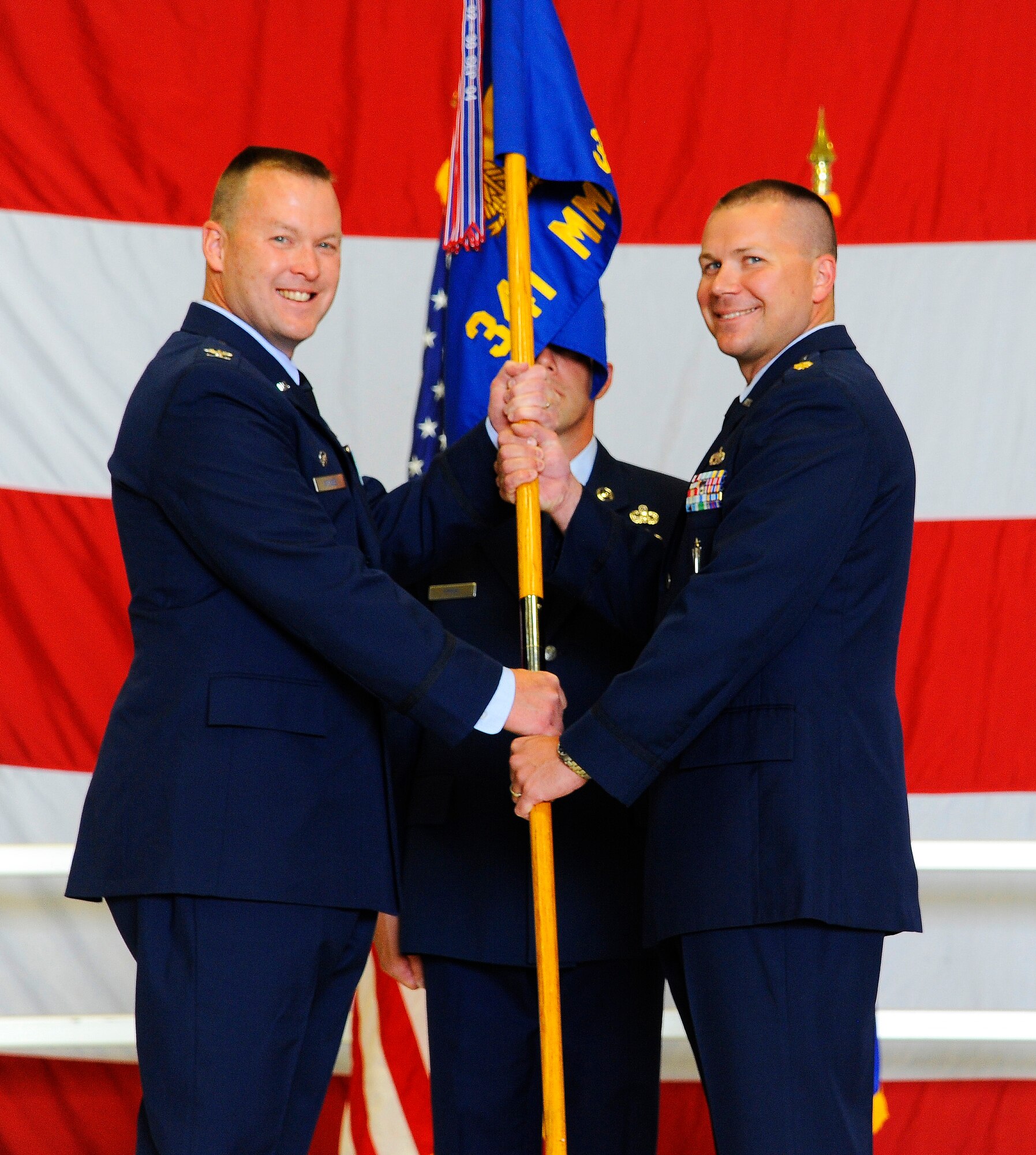 Maj. Michael McConnell (right), accepts command of the 341st Missile Maintenance Squadron from Col. Kenneth Speidel, 341st Maintenance group commander, at the 3 Bay Hangar on July 21. Lt. Col. Thomas Vance was the relinquishing commander of the 341st MMXS. (U.S. Air Force photo/Airman 1st Class Collin Schmidt)