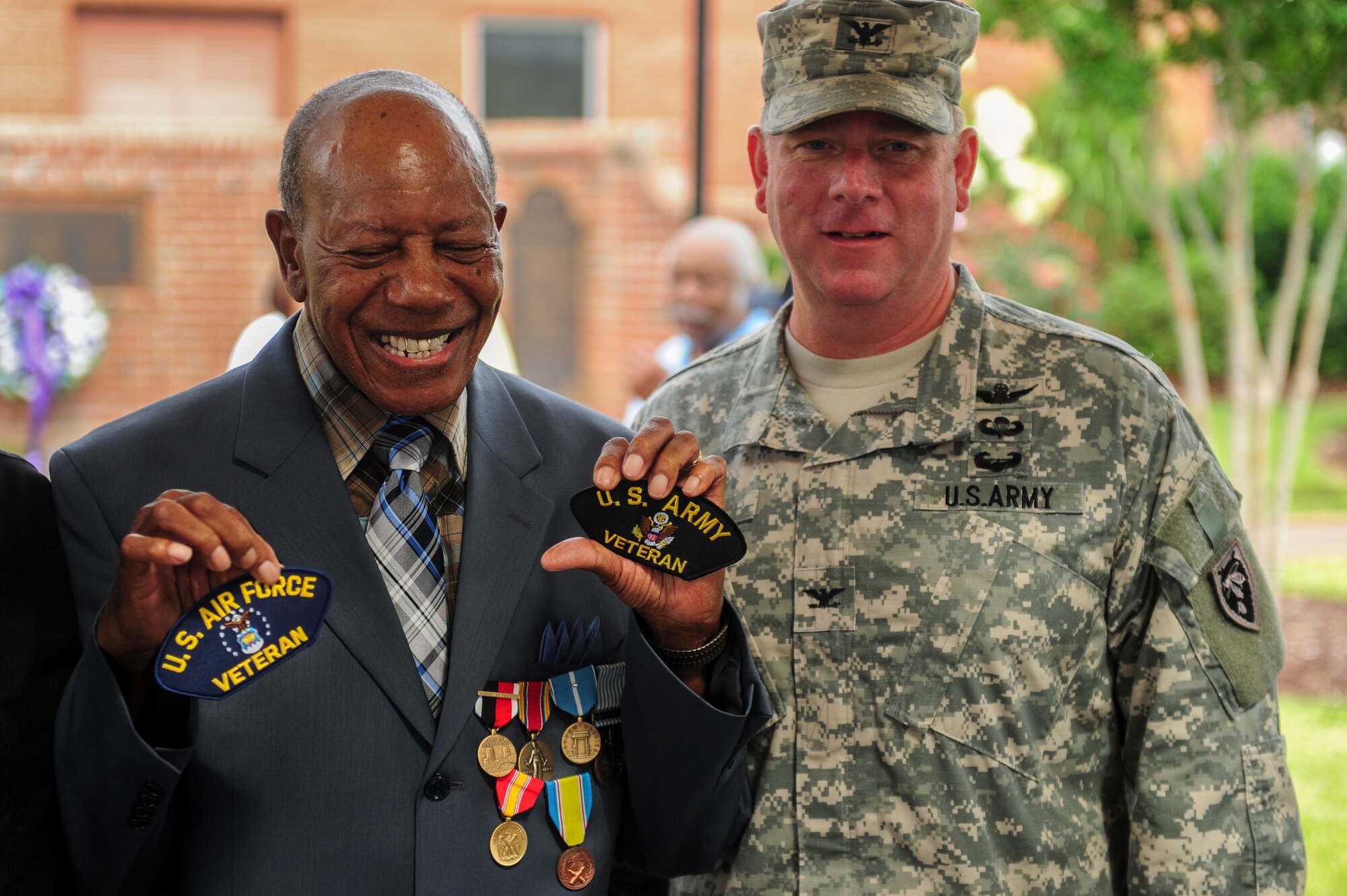 Retired Staff Sgt. Elbert Scott celebrates with U.S. Army Col.Todd Hunt, Vice Chief of Staff, Joint Forces Headquarters, North Carolina National Guard, during a medal presentation ceremony in his honor, July 21, 2014, in downtown Goldsboro, North Carolina. Representatives from Seymour Johnson Air Force Base, the North Carolina National Guard, the Wayne County Veterans and Patriots Coalition and the Office of U.S. Senator Kay Hagan joined forces to present Scott with the medals. (U.S. Air Force photo/Airman 1st Class Brittain Crolley)
