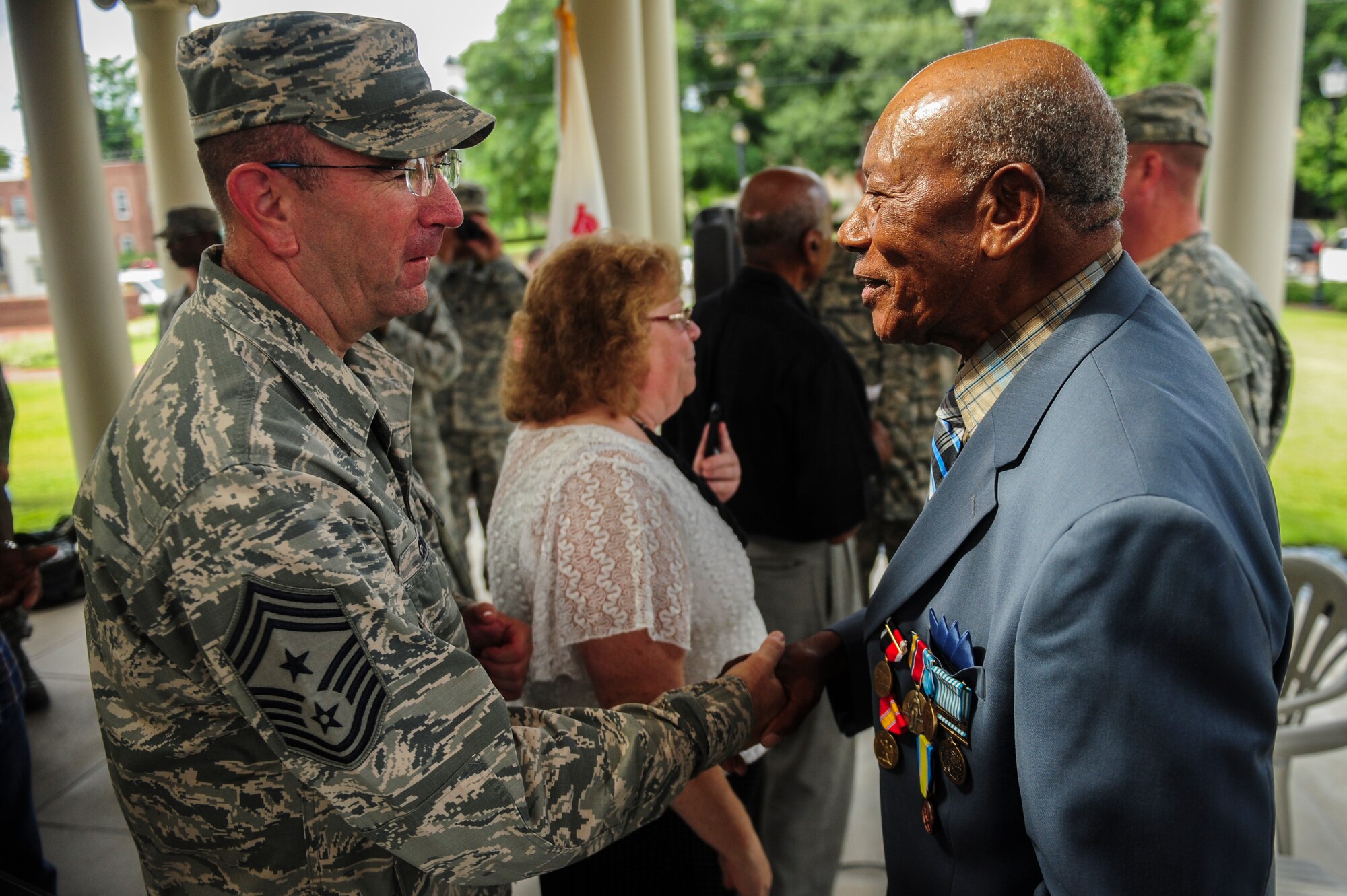 Chief Master Sgt. Jeffrey Craver, 4th Fighter Wing command chief, shakes hands with retired Staff. Sgt. Elbert Scott after a medal presentation ceremony, July 21, 2014, in downtown Goldsboro, North Carolina. Scott was presented six medals for his service during World War II and the Korean War. (U.S. Air Force photo/Airman 1st Class Brittain Crolley)